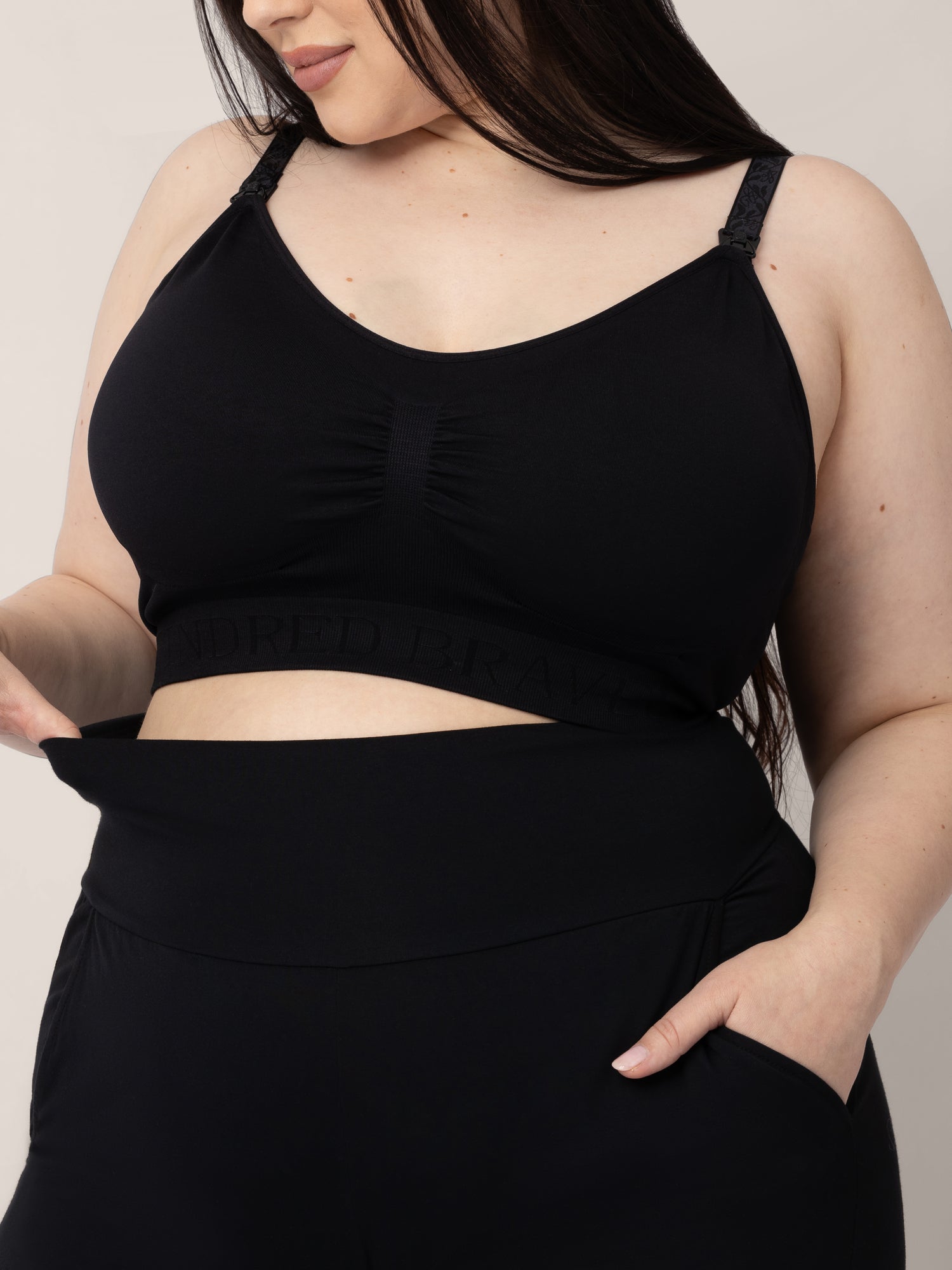 Pregnant model wearing the Bamboo Wide Leg Maternity & Postpartum Lounge Pant in Black and the Sublime® Hands-Free Pumping & Nursing Sports Bra in black 