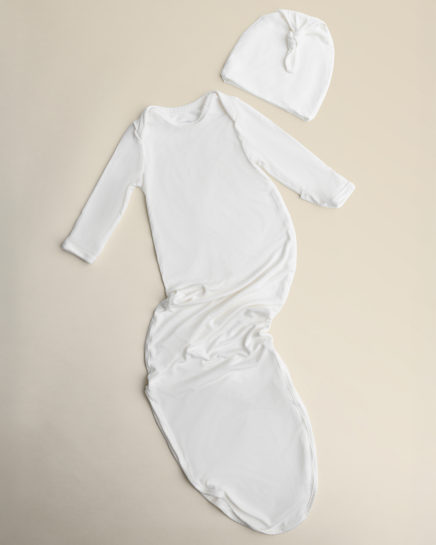 Bamboo Knotted Baby Gown in Pearl on a beige background