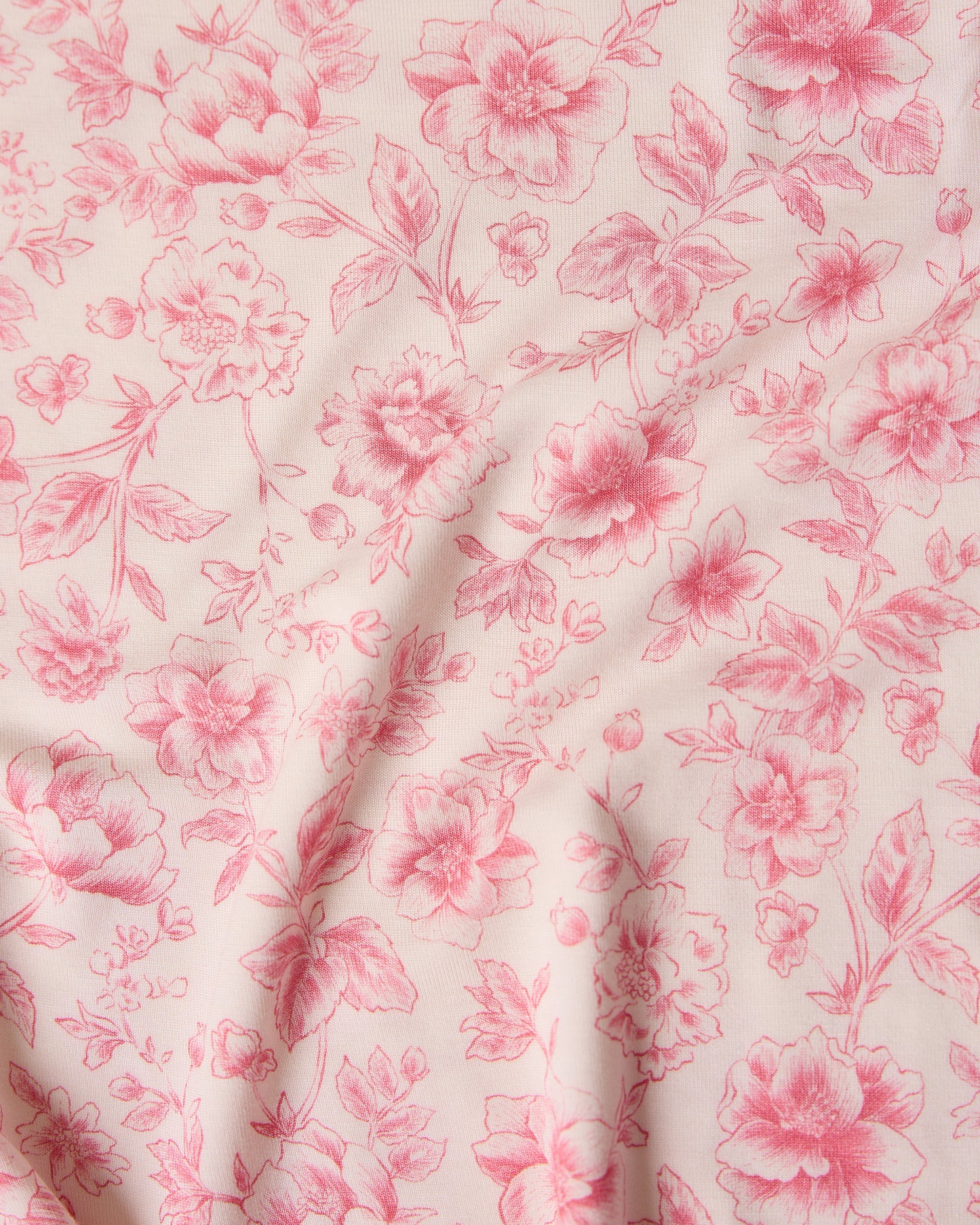 Close-up of pink toile floral fabric pattern with pink flowers on a light background