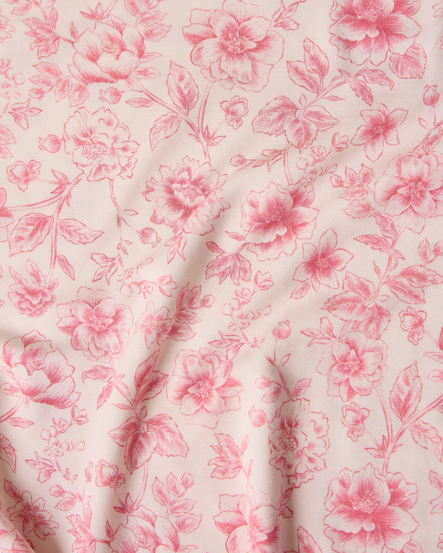Close-up of pink toile floral fabric pattern with pink flowers on a light background