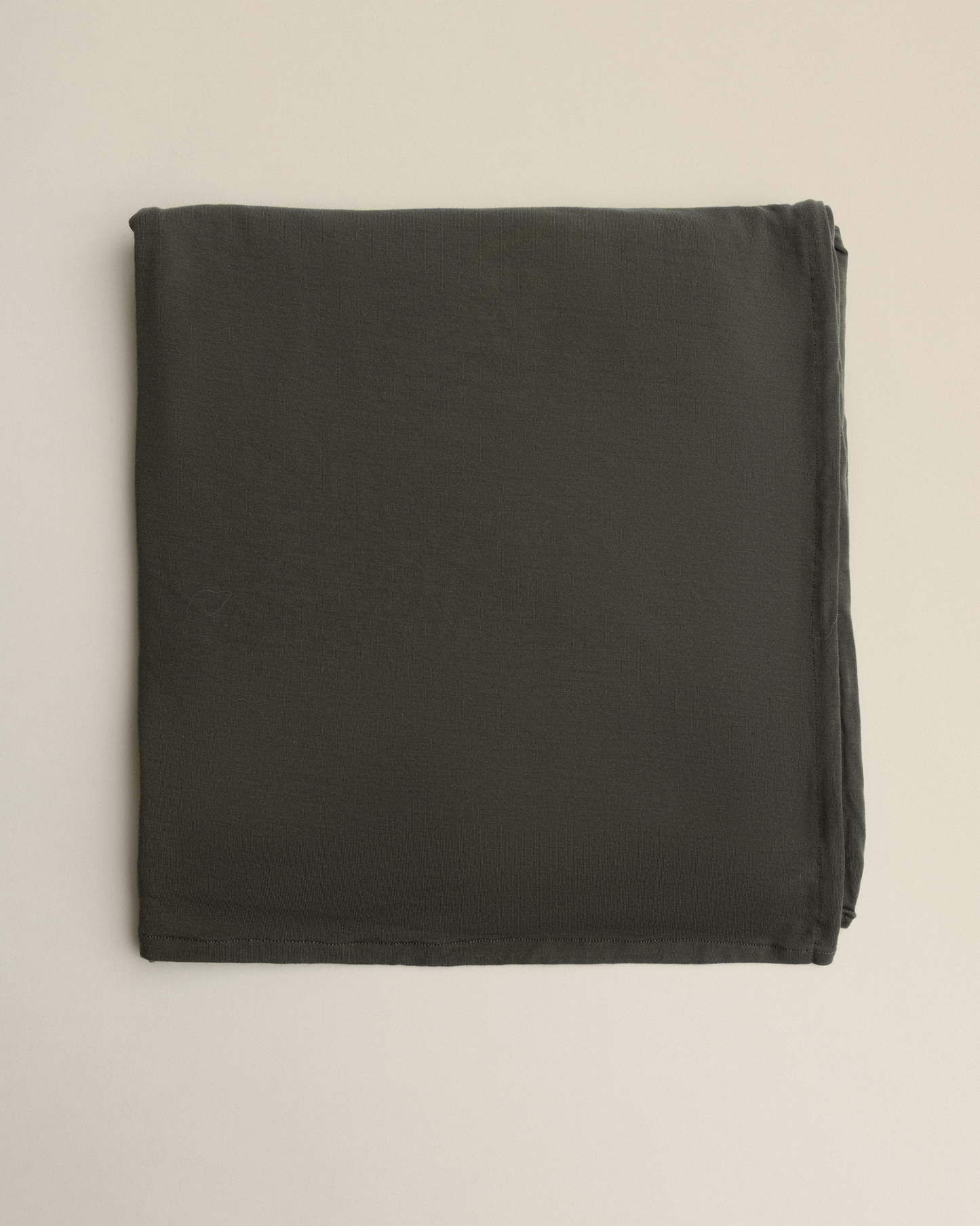 Bamboo Swaddle Blanket in Thyme on a beige background