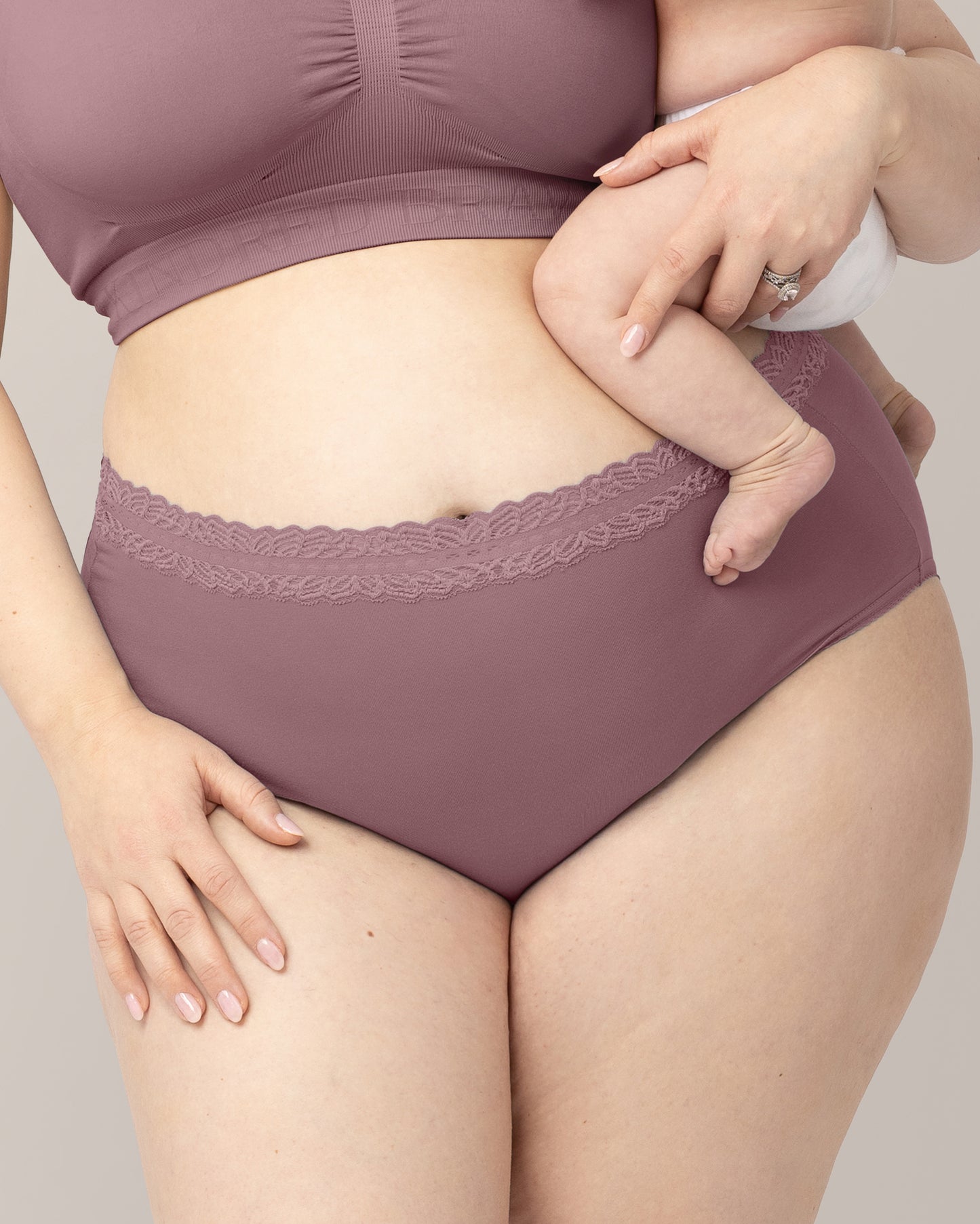 Person wearing high-waisted underwear with lace waistband against a neutral background@model_info:Rachel is wearing an X-Large.