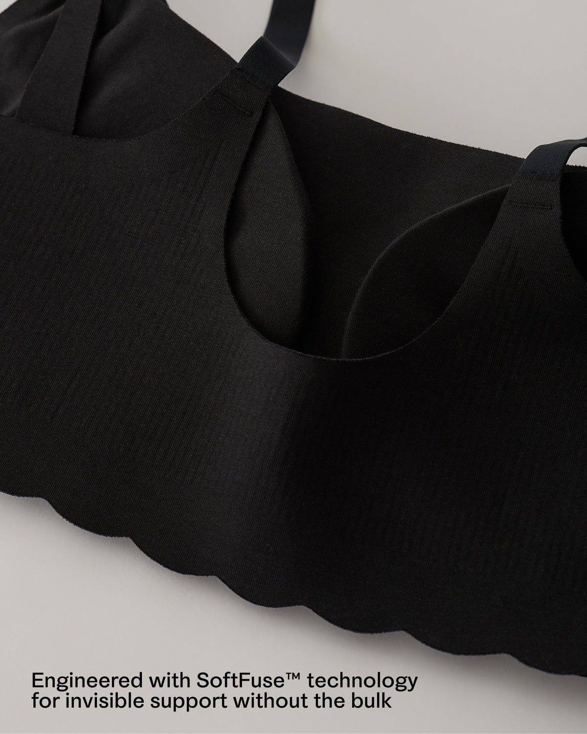 Close-up of scalloped edges of the BareBond™ Cotton Maternity & Nursing Bralette in Black, featuring a text overlay at the bottom that reads 'Engineered with SoftFuse™ technology for invisible support without the bulk'.