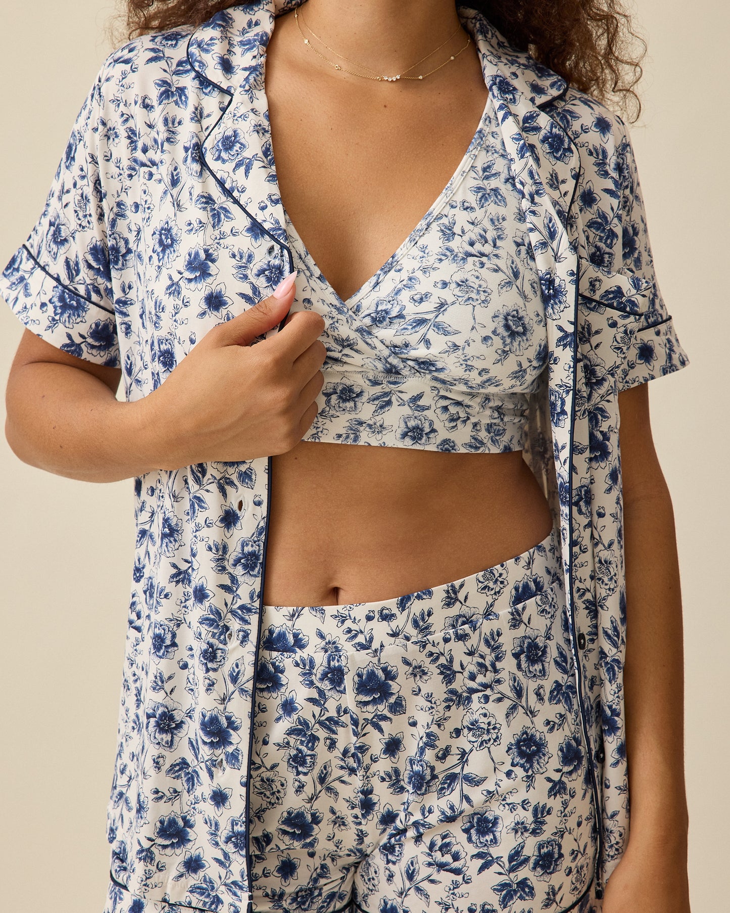 Woman wearing the Clea Bamboo Short Sleeve Pajama Set in navy toile with coordinating bra against a beige background 