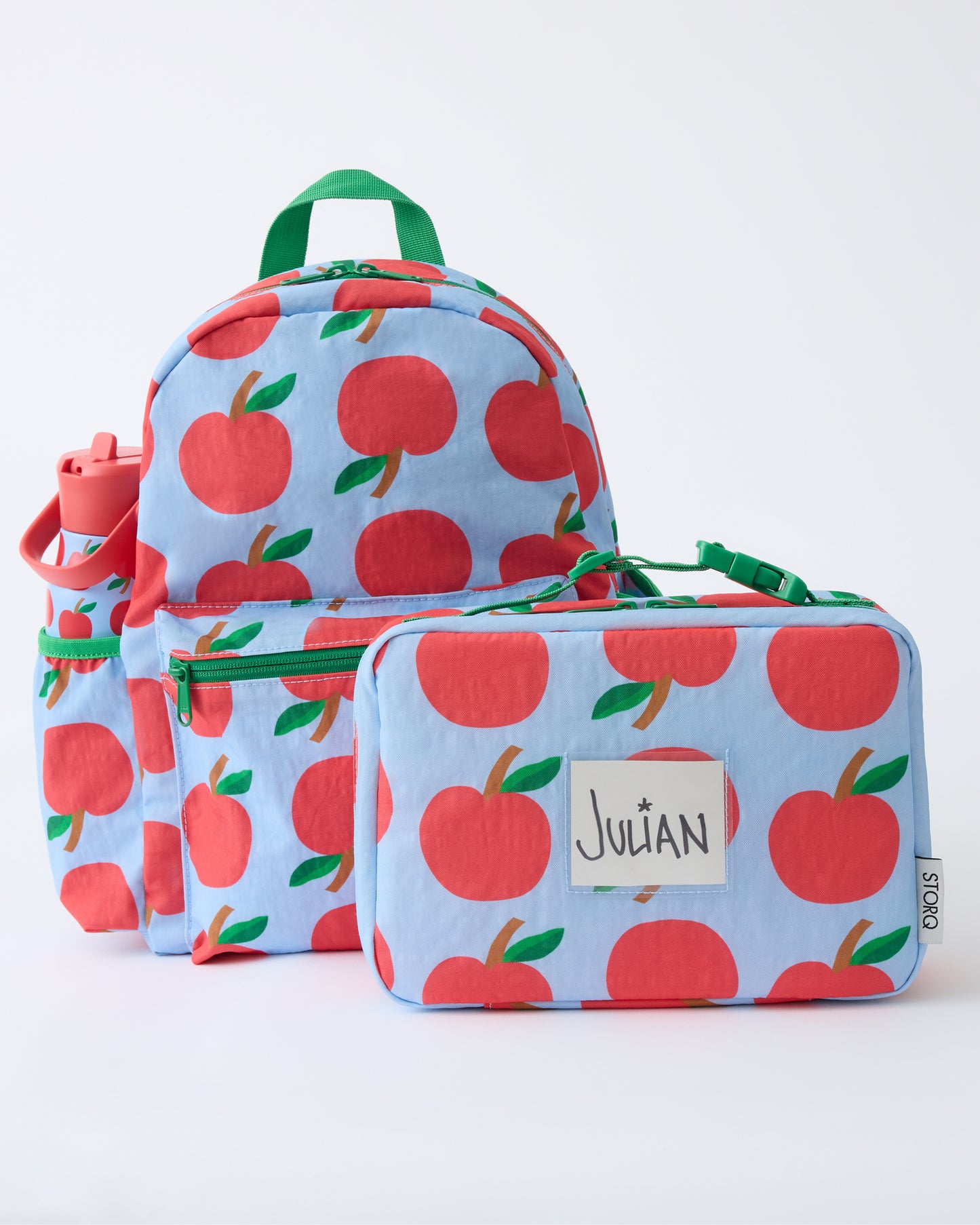The Cool Kid Backpack, Water Bottle and Lunch Box in Blue Apple on a beige background.