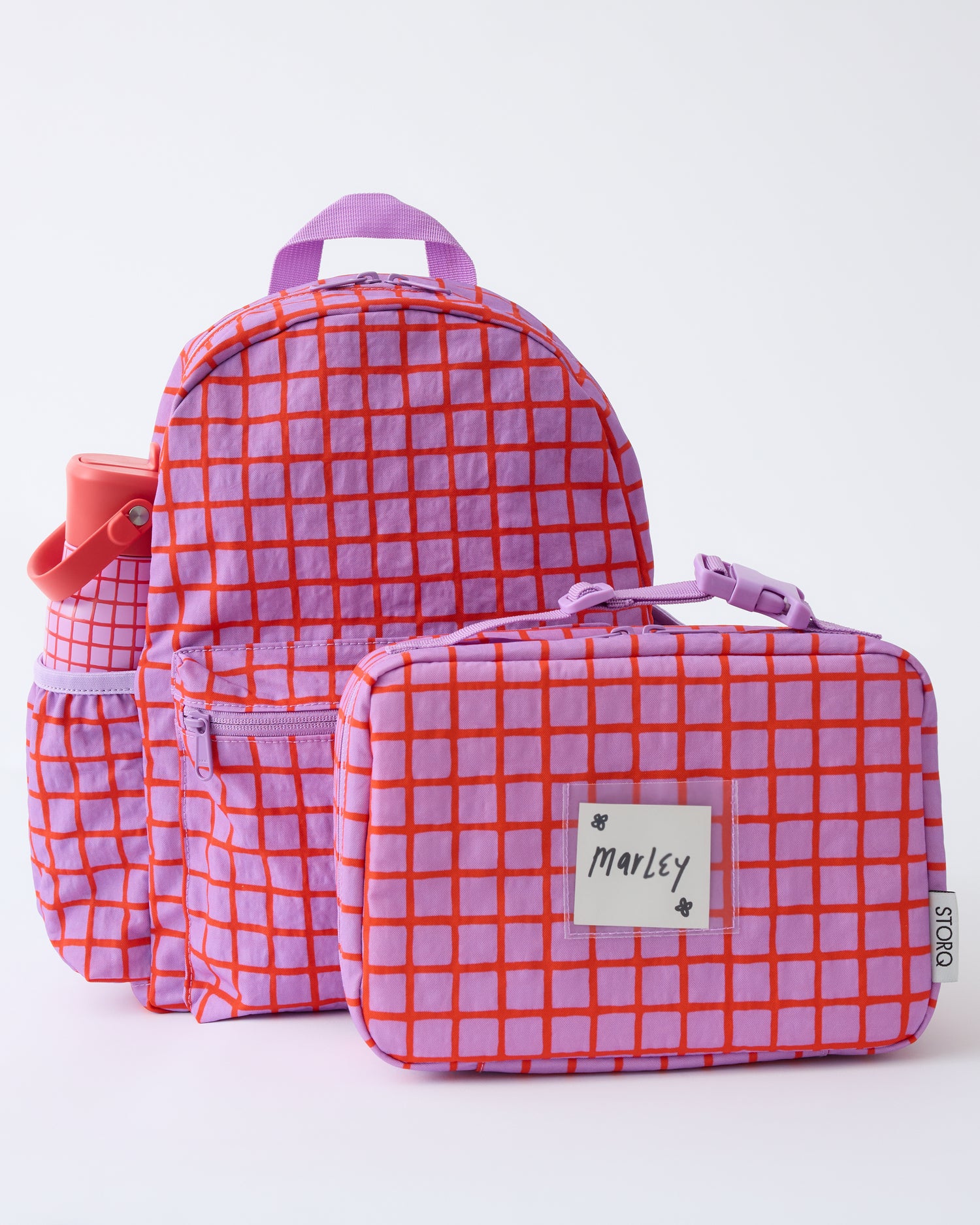 Cool Kid Backpack, Water Bottle and Lunch Box in Orchid Grid on a beige background.
