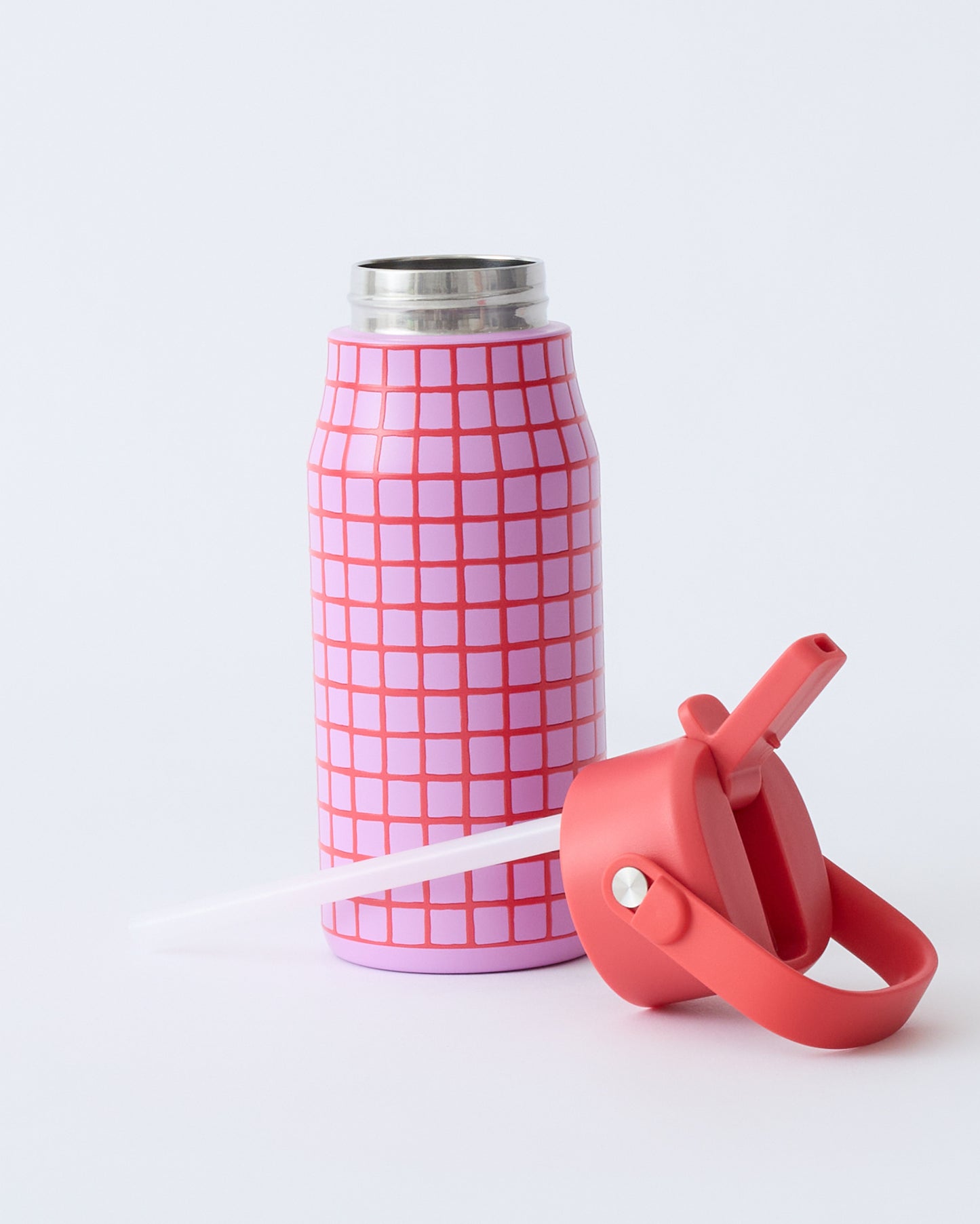 Cool Kid Water Bottle in Orchid Grid, opened with lid and straw laying in front of bottle, on a beige background.