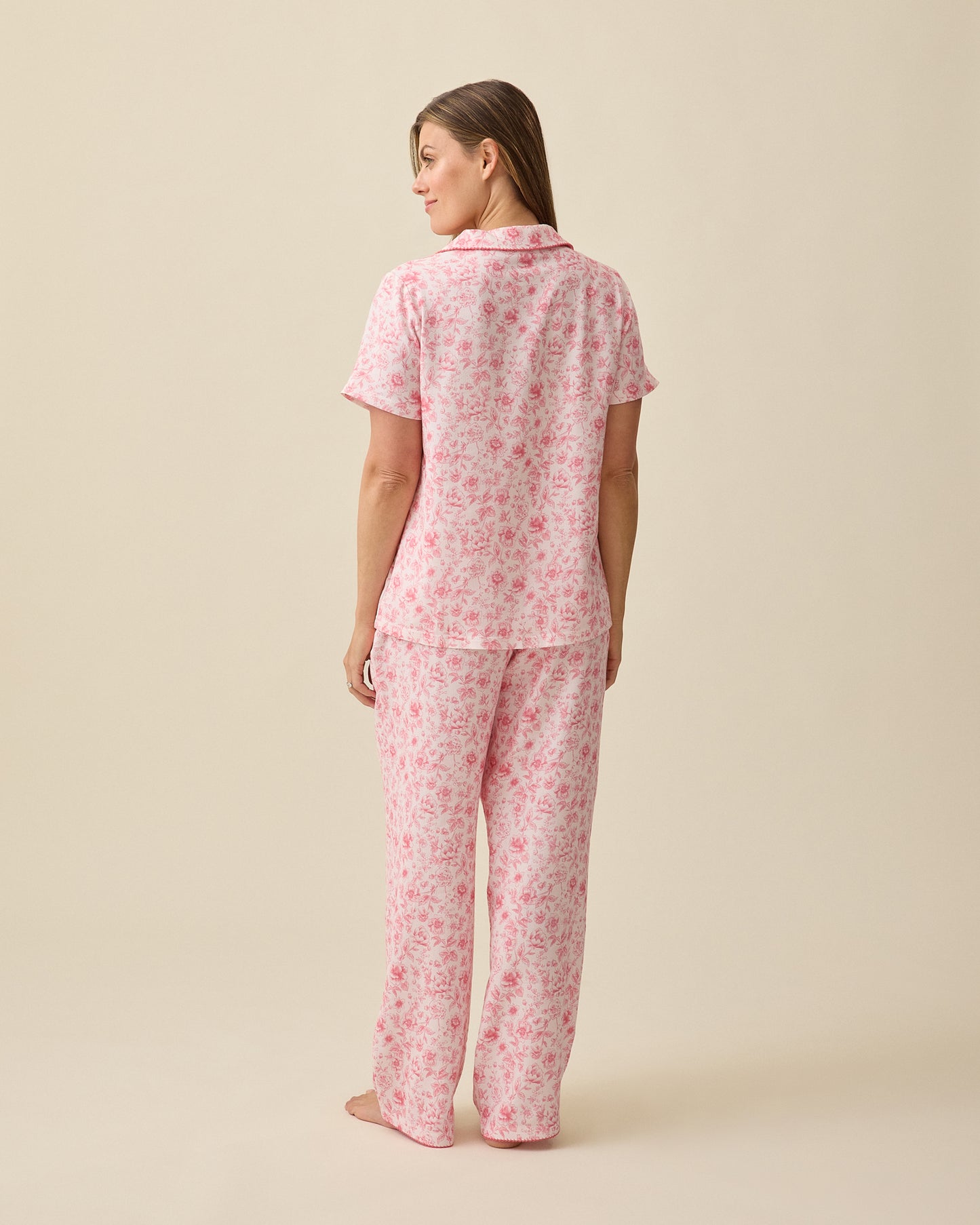 Model displaying back view of Cotton Bamboo Pajama Set in Pink Toile on a beige background.