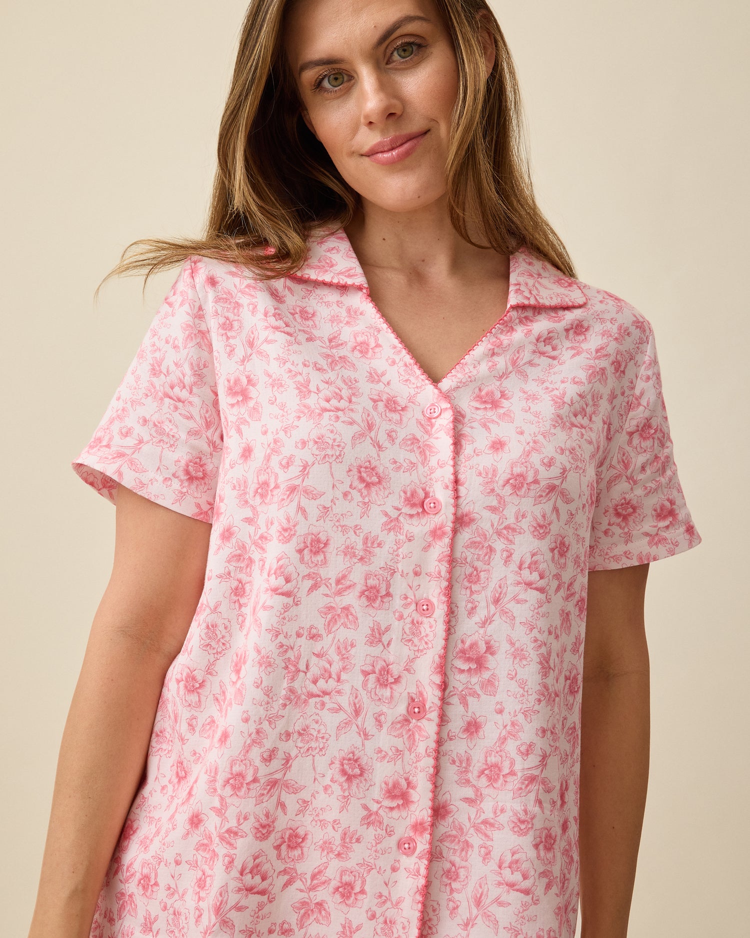 Model wearing Cotton Bamboo Pajama Set in Pink Toile on a beige background.