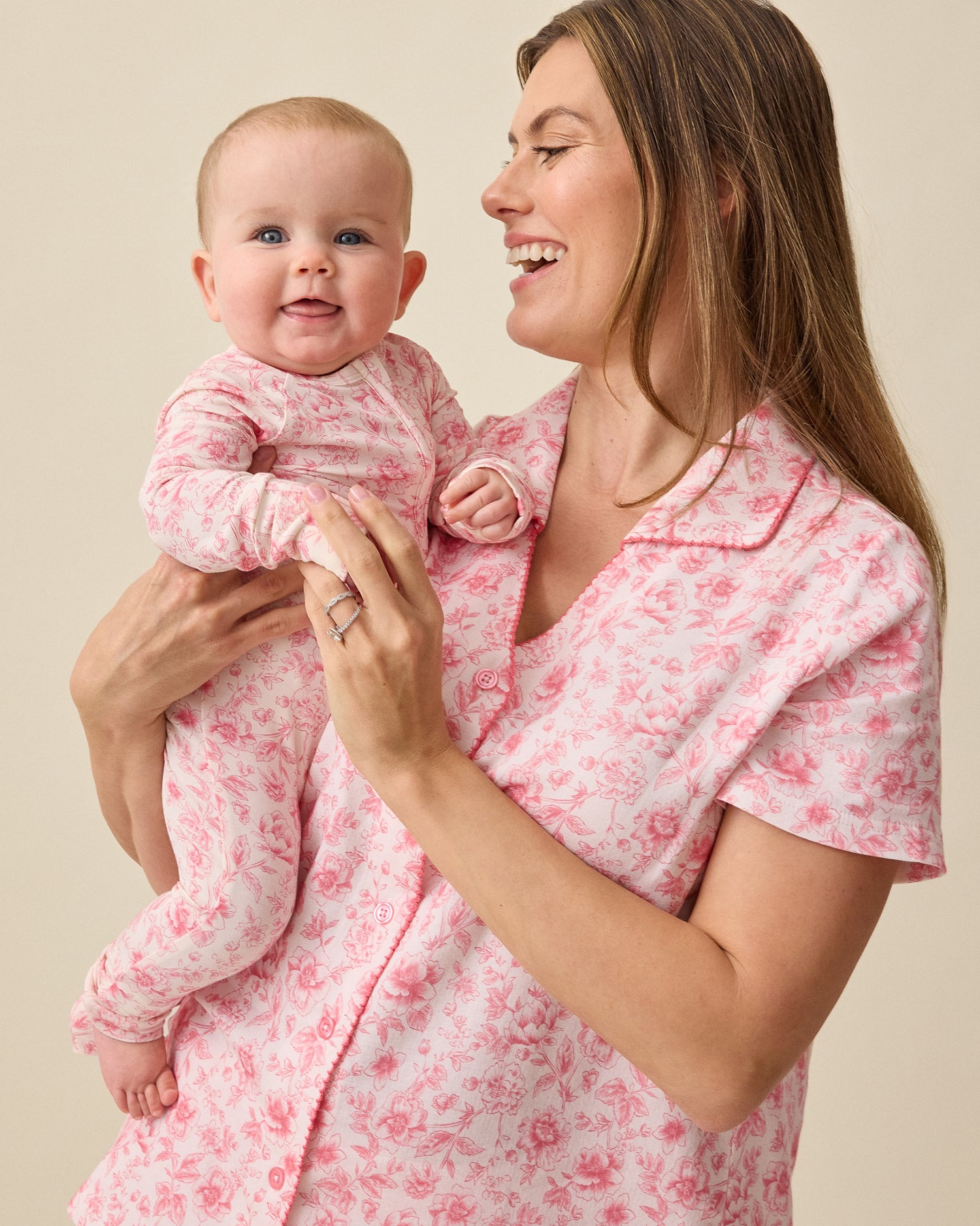 Baby and woman wearing Bamboo Baby Pajama and Bamboo Two-Piece Pajama Set in Pink Toile on a beige background.