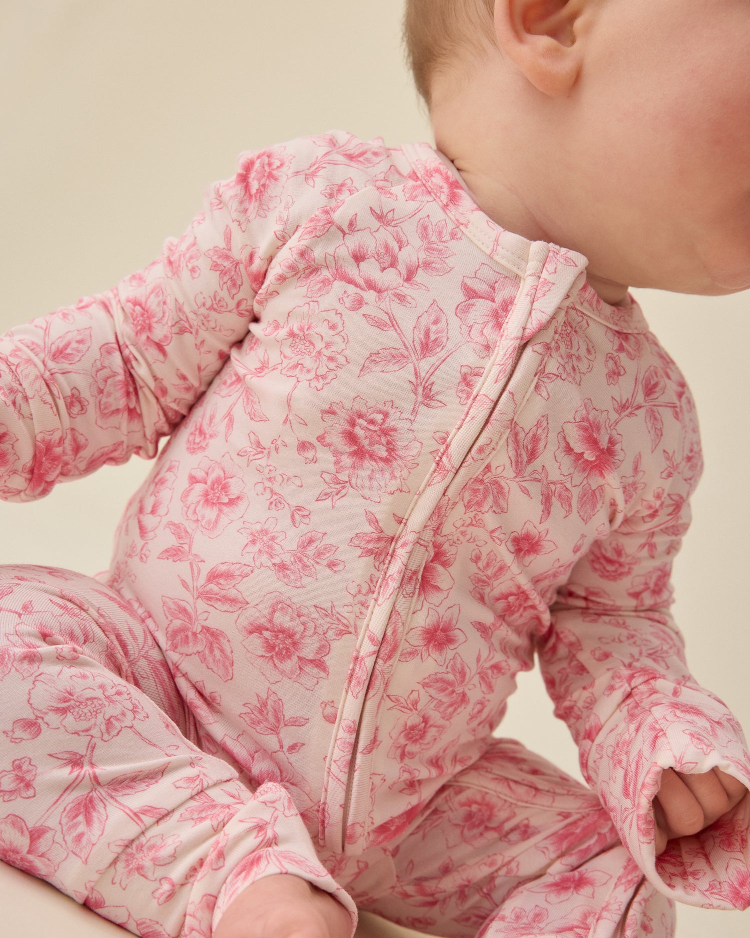 Baby wearing Bamboo Baby Pajama in pink toile on a beige background