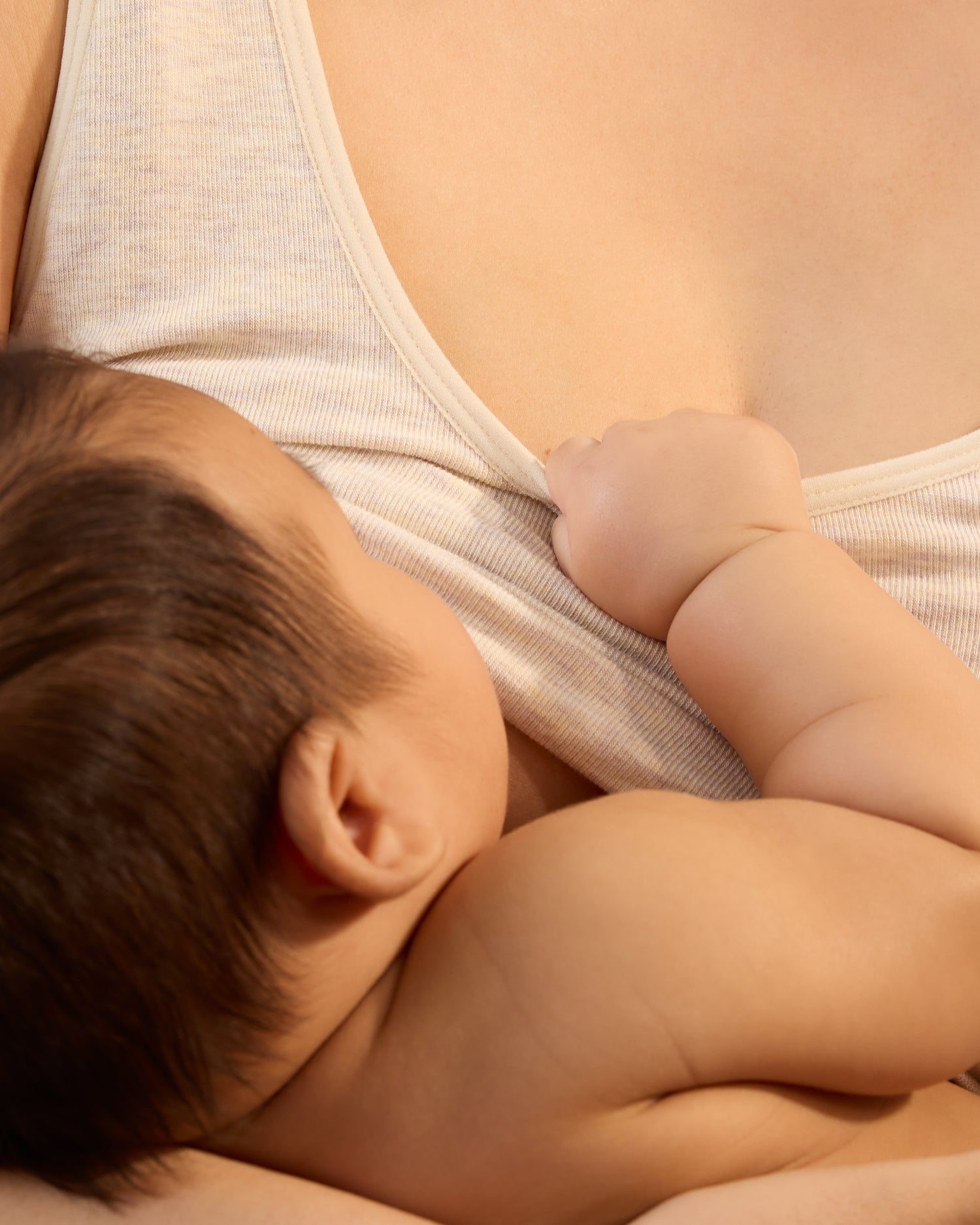 Close up of model wearing Sublime® Bamboo Scoop Neck Maternity & Nursing Longline Bra Top in Oatmeal Heather with a baby nursing