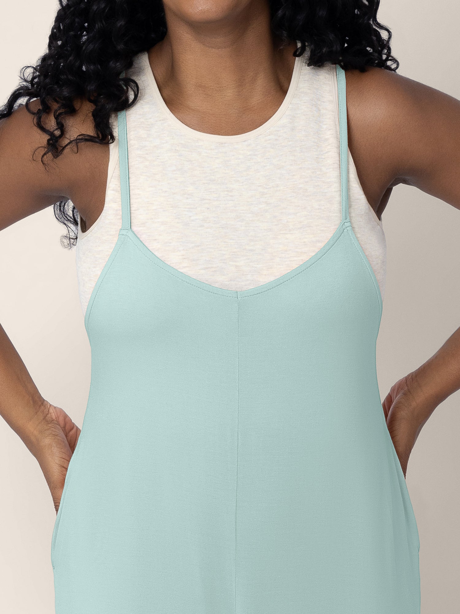 A close up shot of a model wearing the Charlie Maternity & Nursing Romper in Dusty Blue Green, showing the easy pull down nursing access