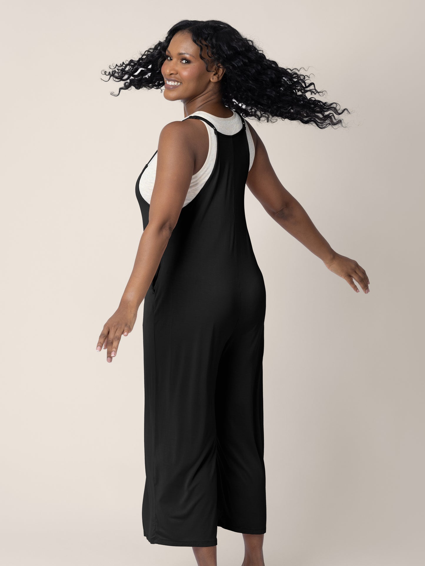 A model wearing the Charlie Maternity & Nursing Romper in Black, giving a spin 