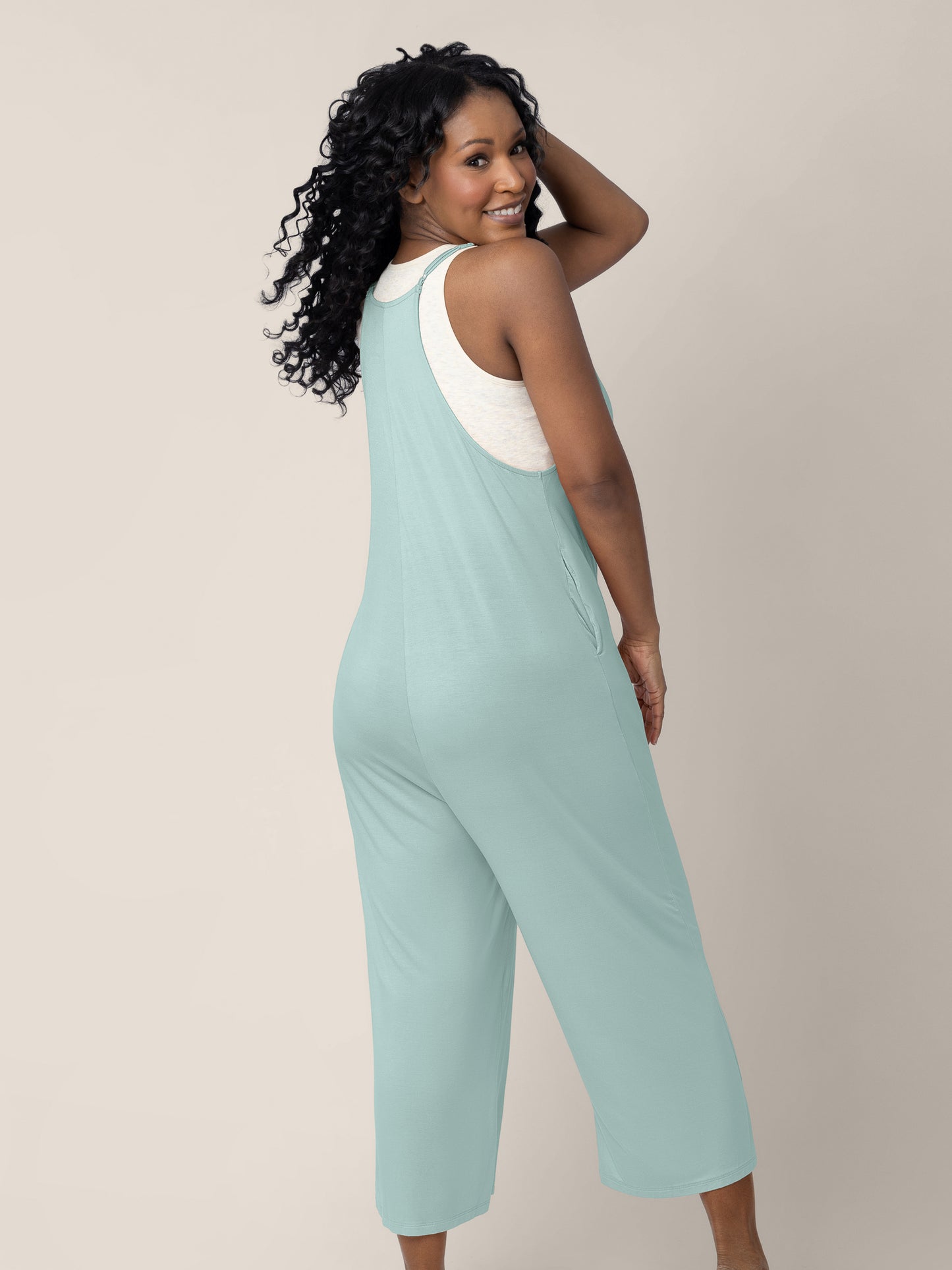 A back view of a model wearing the Charlie Maternity & Nursing Romper in Dusty Blue Green