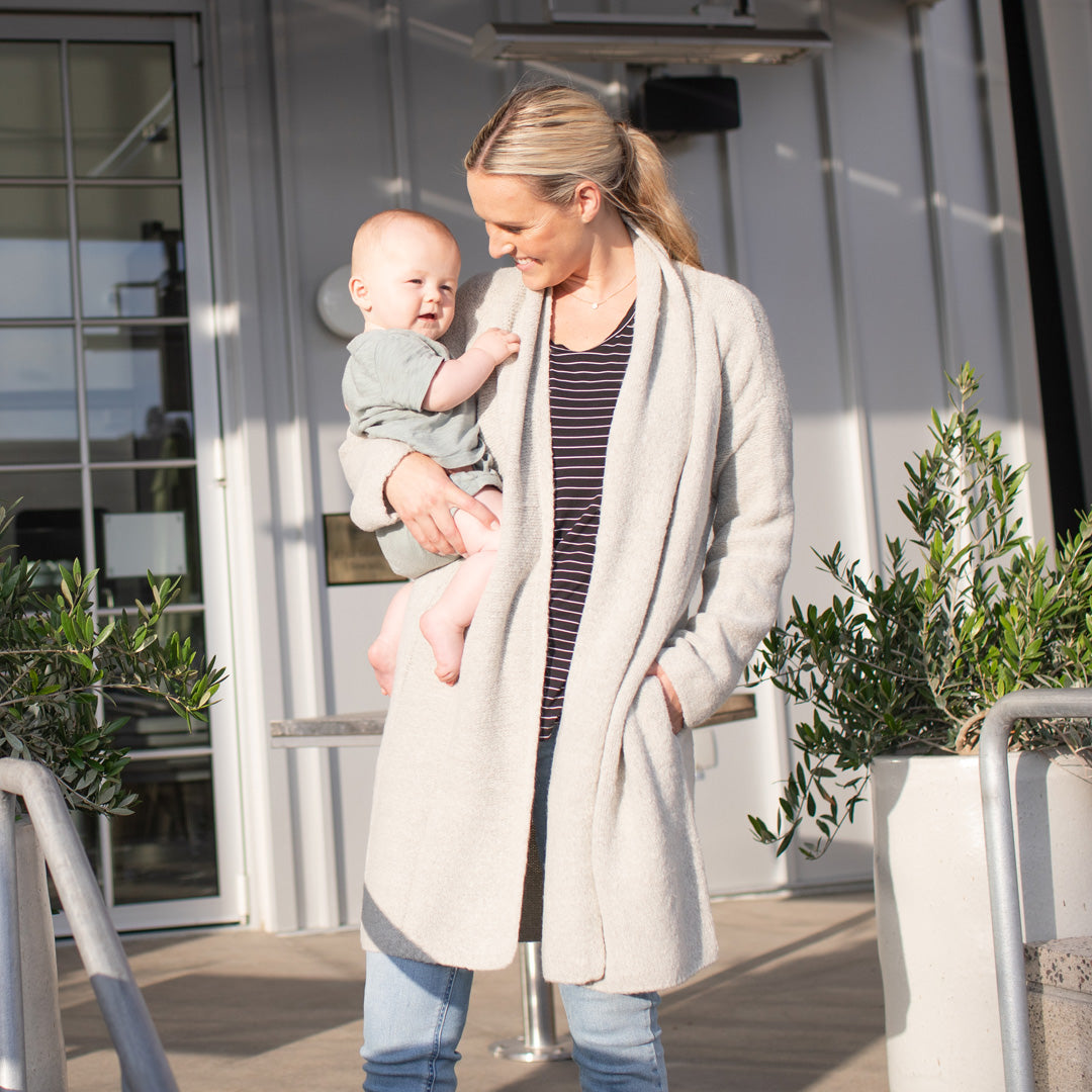 Model wearing the Chloe Cardigan Sweater in Grey Heather with her baby on her hip. @model_info:Maddy is wearing an XS/S.