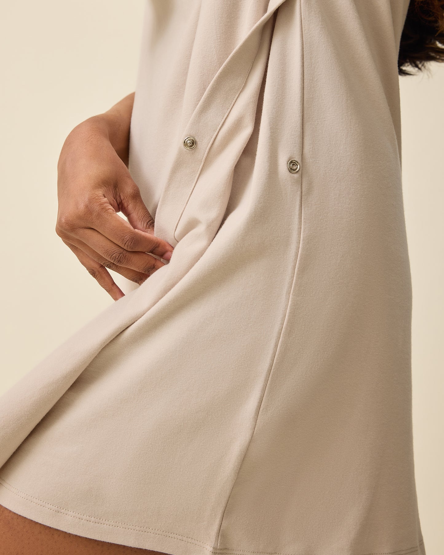 Woman wearing the Classic Nursing T-shirt Mini Dress in Sand, showing side snap for nursing access