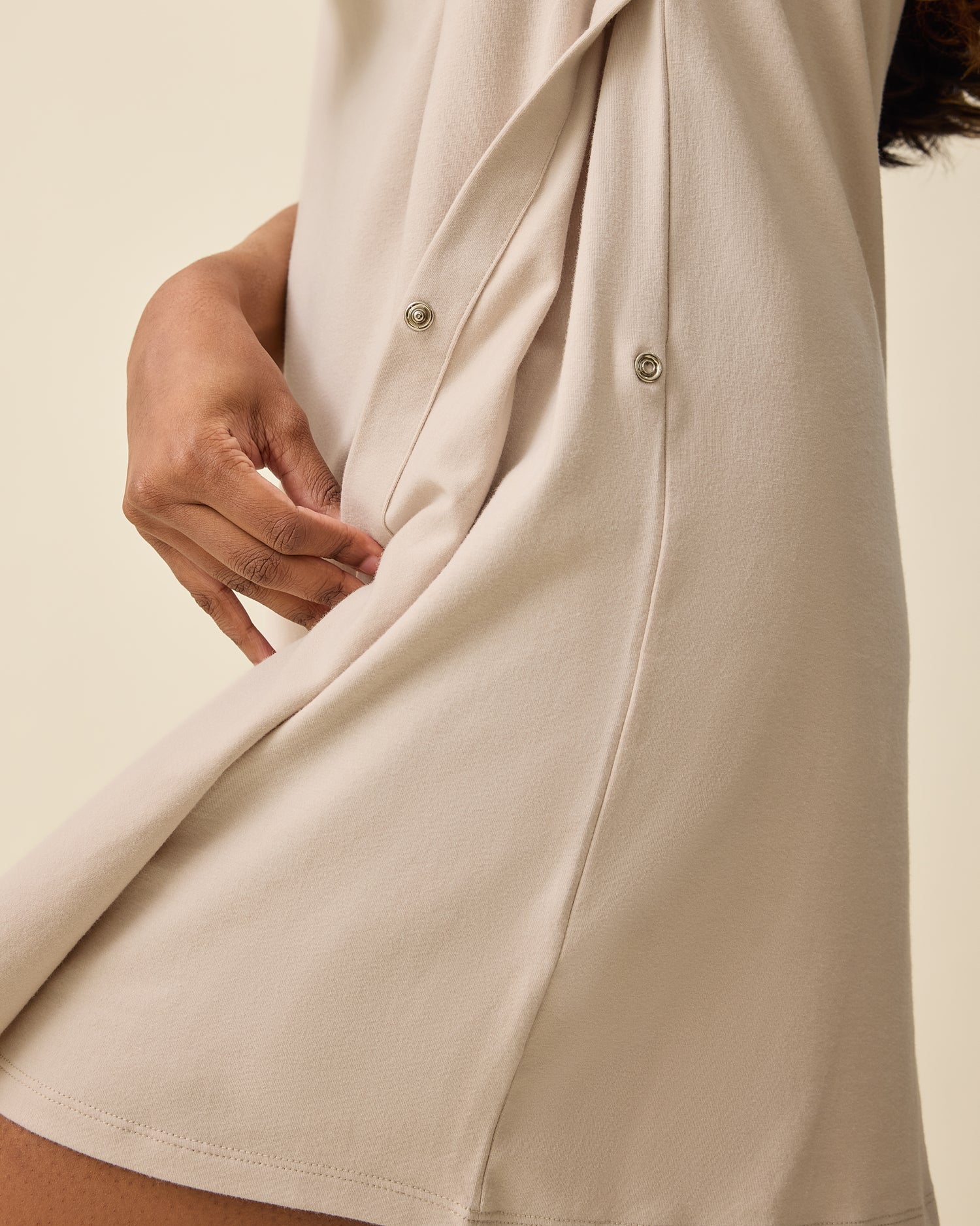 Woman wearing the Classic Nursing T-shirt Mini Dress in Sand, showing side snap for nursing access
