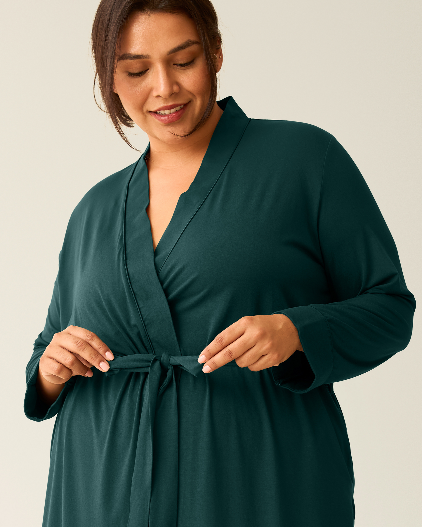 woman wearing the Clea Bamboo Robe in Evergreen, pulling loops on tie