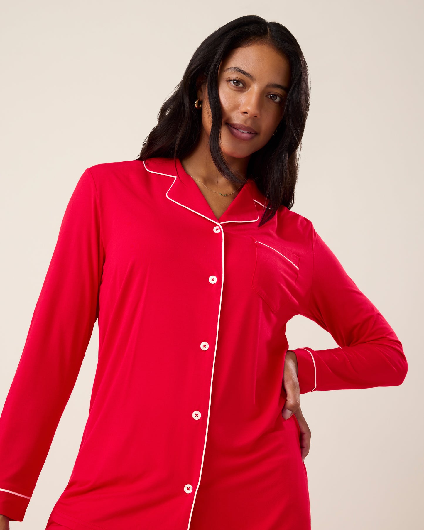 Woman wearing the Clea Bamboo Long Sleeve Pajama Set in Red, with white piping