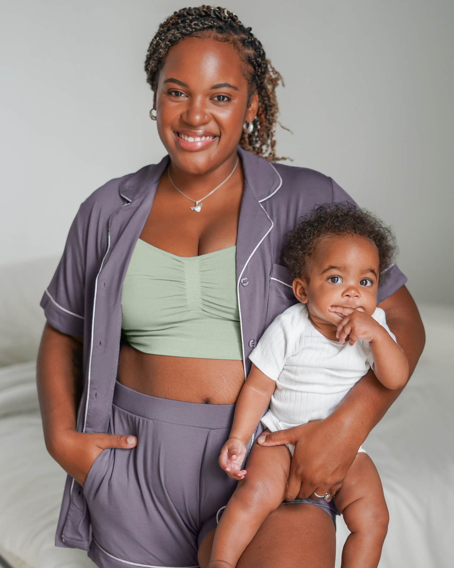 Model holding baby wearing the  Sublime® Bamboo Hands-Free Pumping Lounge & Sleep Bra in Aqua Mist