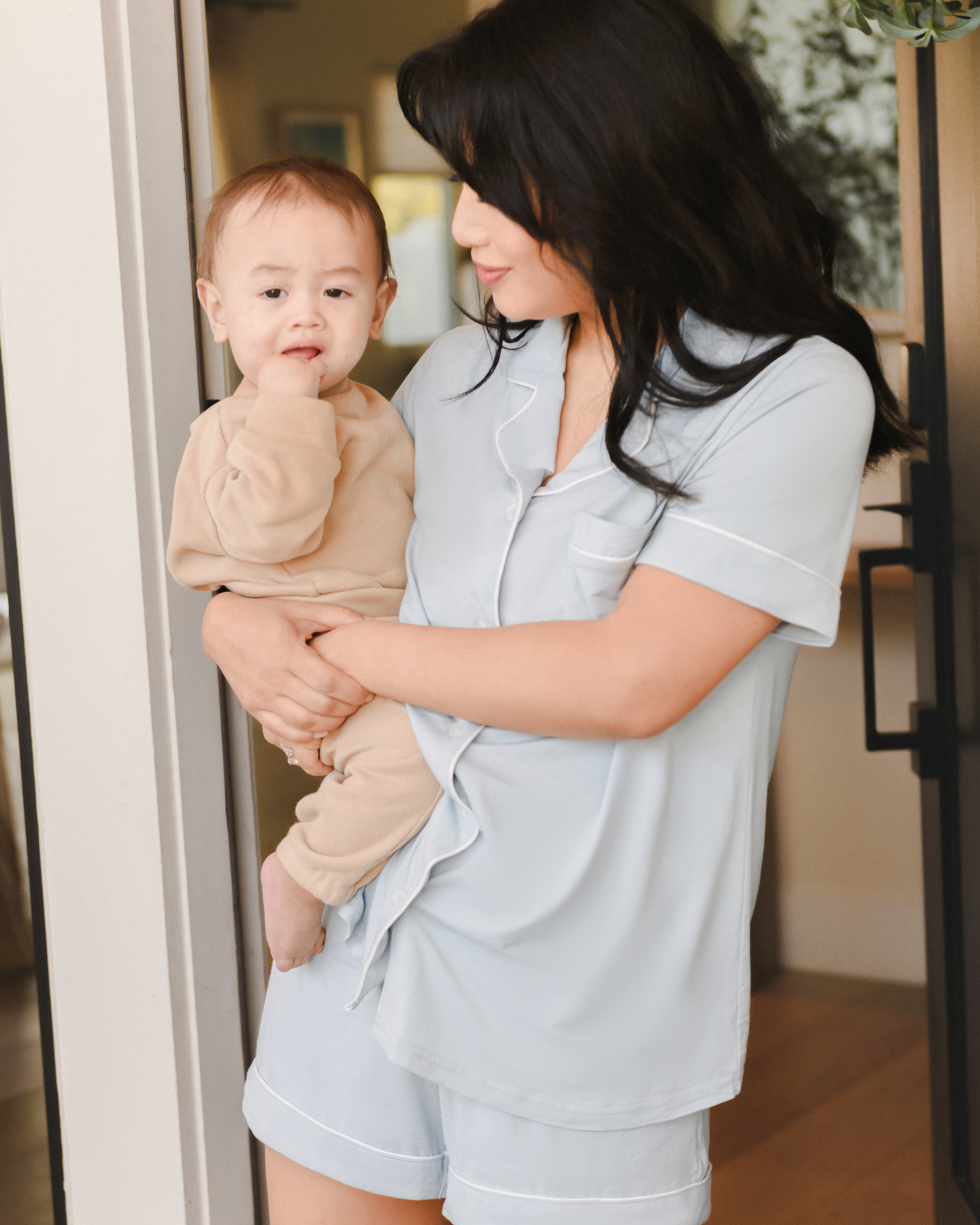 Model holding baby while wearing the Clea Bamboo Short Sleeve Pajama Set in Mist@model_info:Nikki is wearing a Medium.