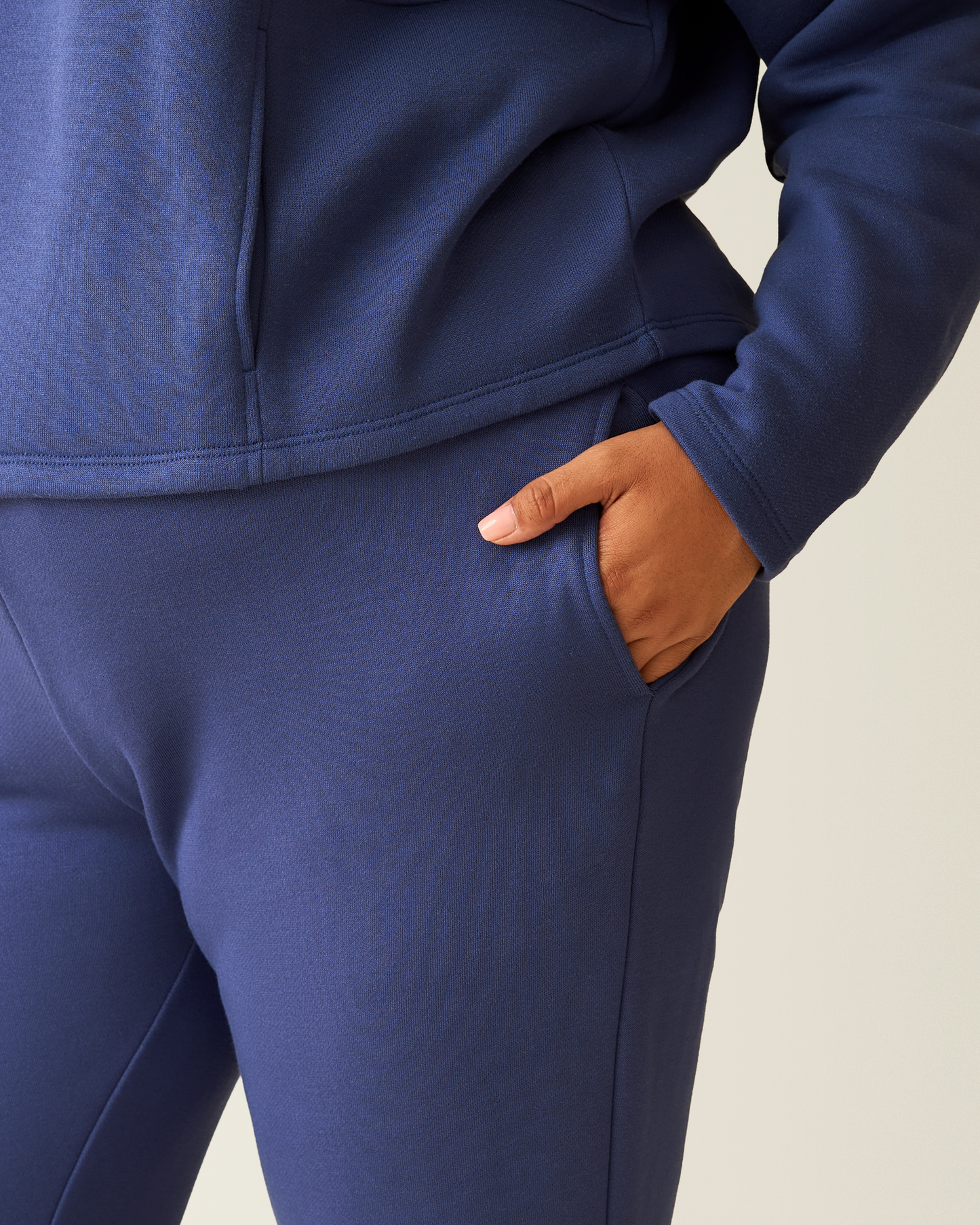 Cropped in image of woman wearing the Cloud Fleece Jogger in Deep Blue with hand in pocket