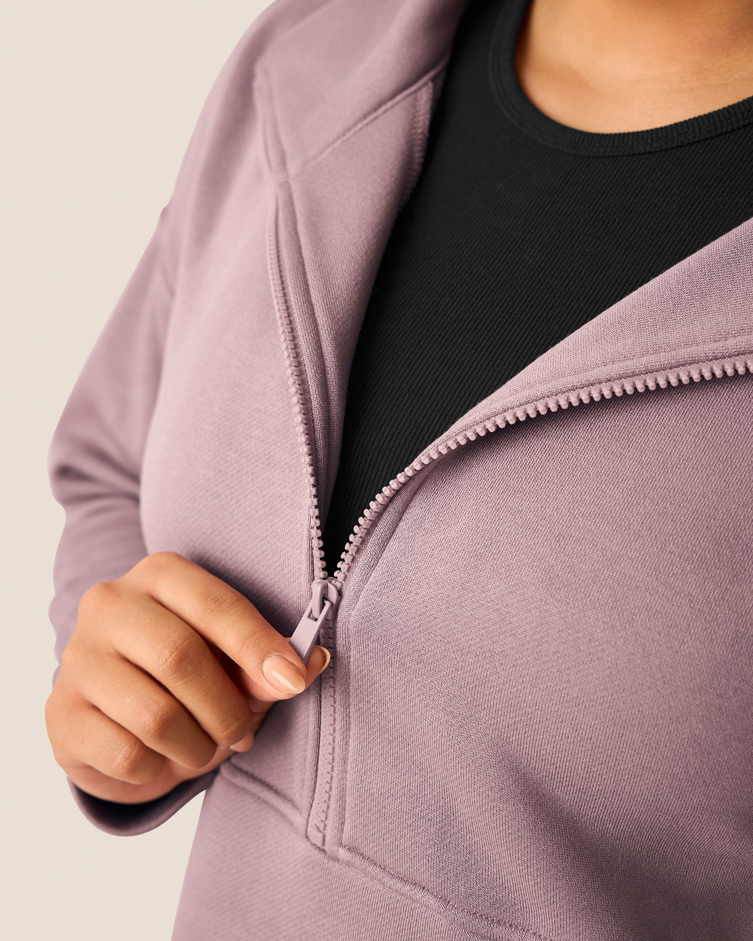 Person wearing a Cloud Fleece dusty mauve zip-up top with black top underneath on a neutral background