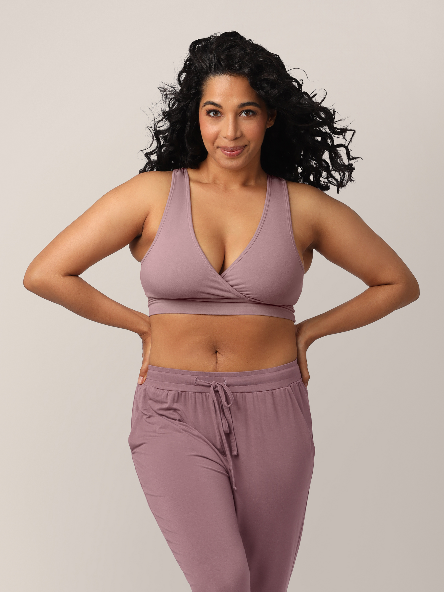 Front view of model wearing the French Terry Racerback Nursing & Sleep Bra in Twilight, with hands on hips @model_info:Zakeeya is wearing a Small.