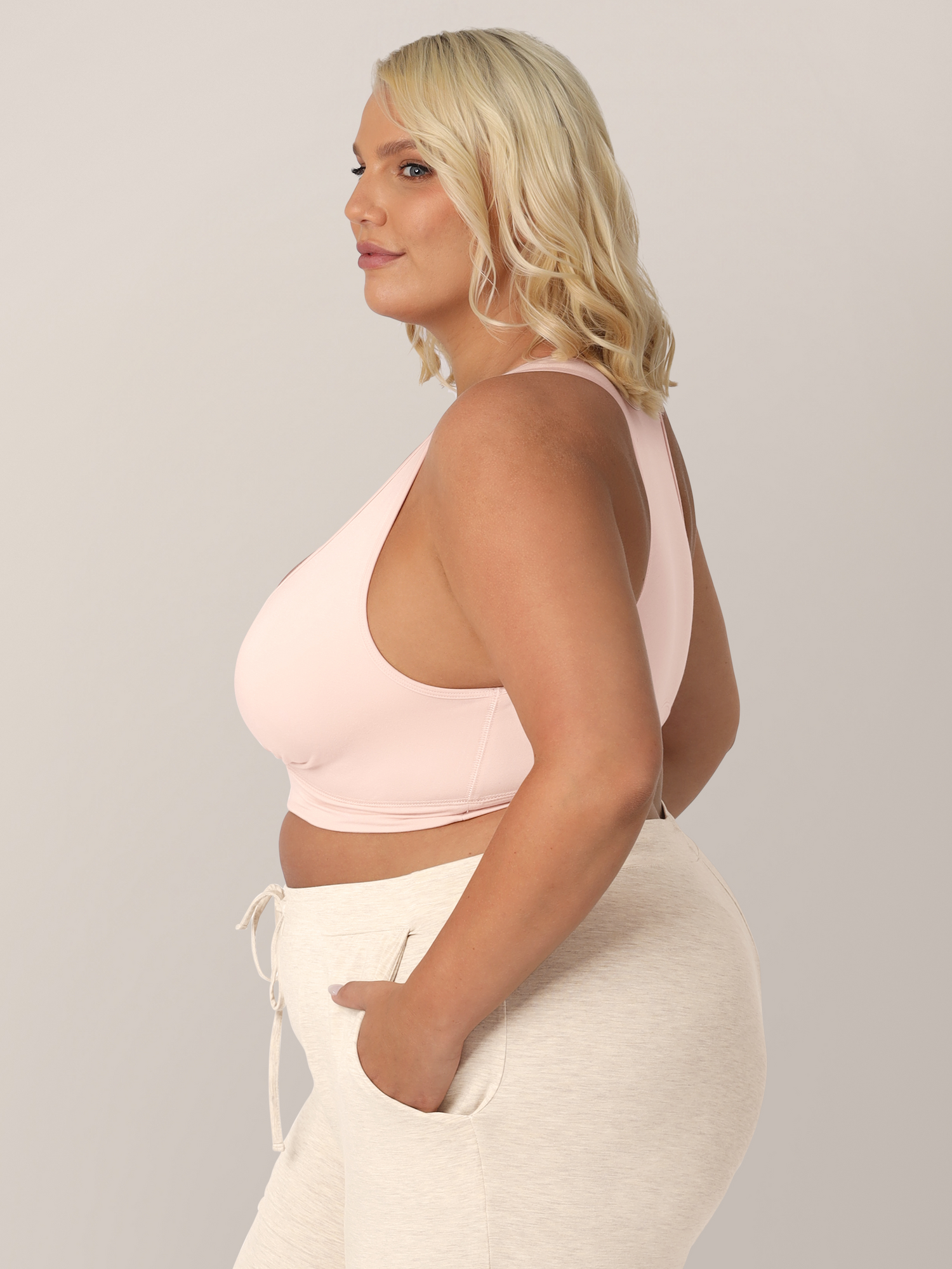 Side view of busty model wearing the French Terry Nursing Bra in Soft Pink. 
