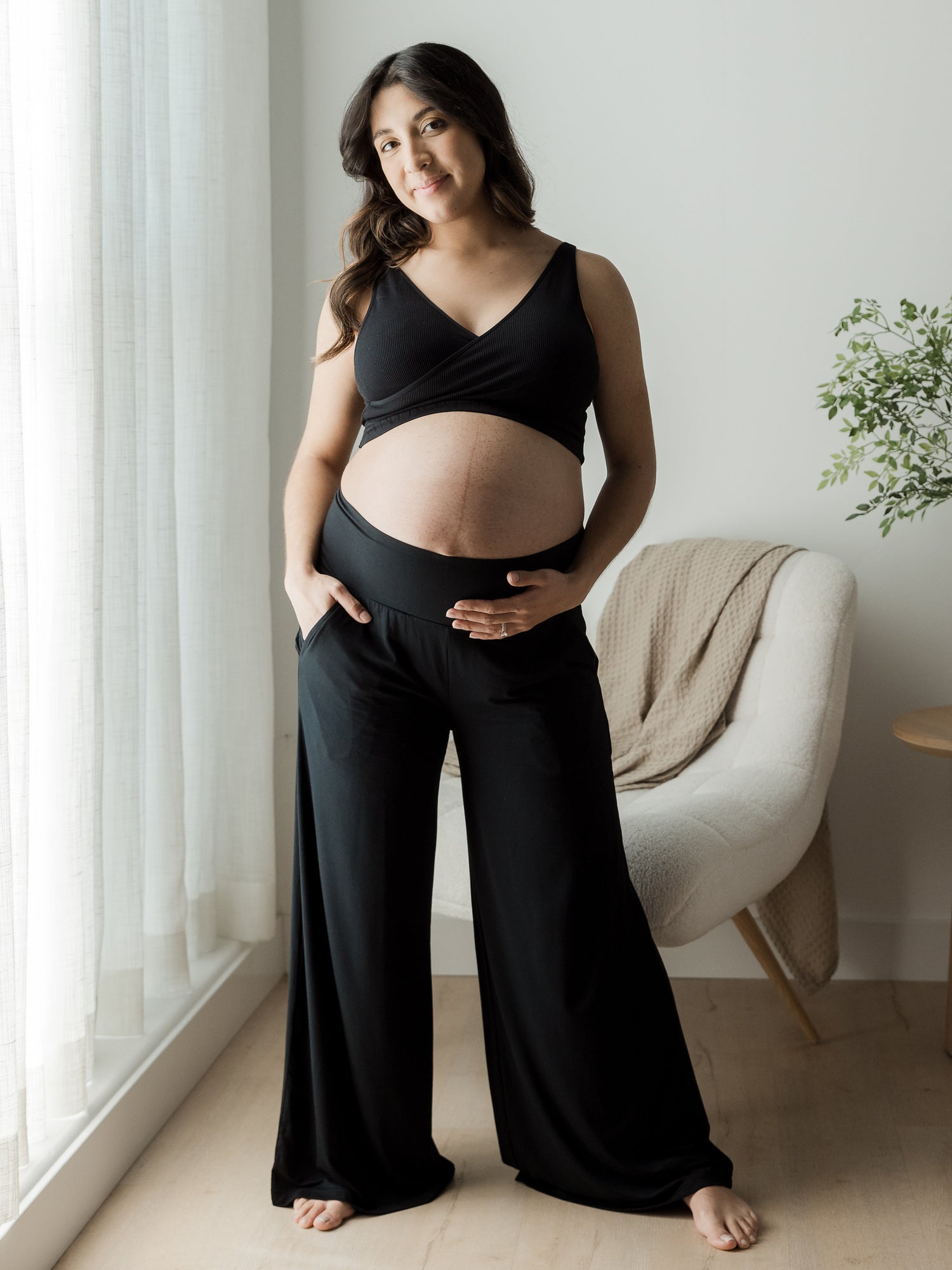 Front full view of Bamboo Wide Leg Maternity & Postpartum Lounge Pant on pregnant model with hand in pocket@model_info:Patty is 5'4" and wearing a Medium.