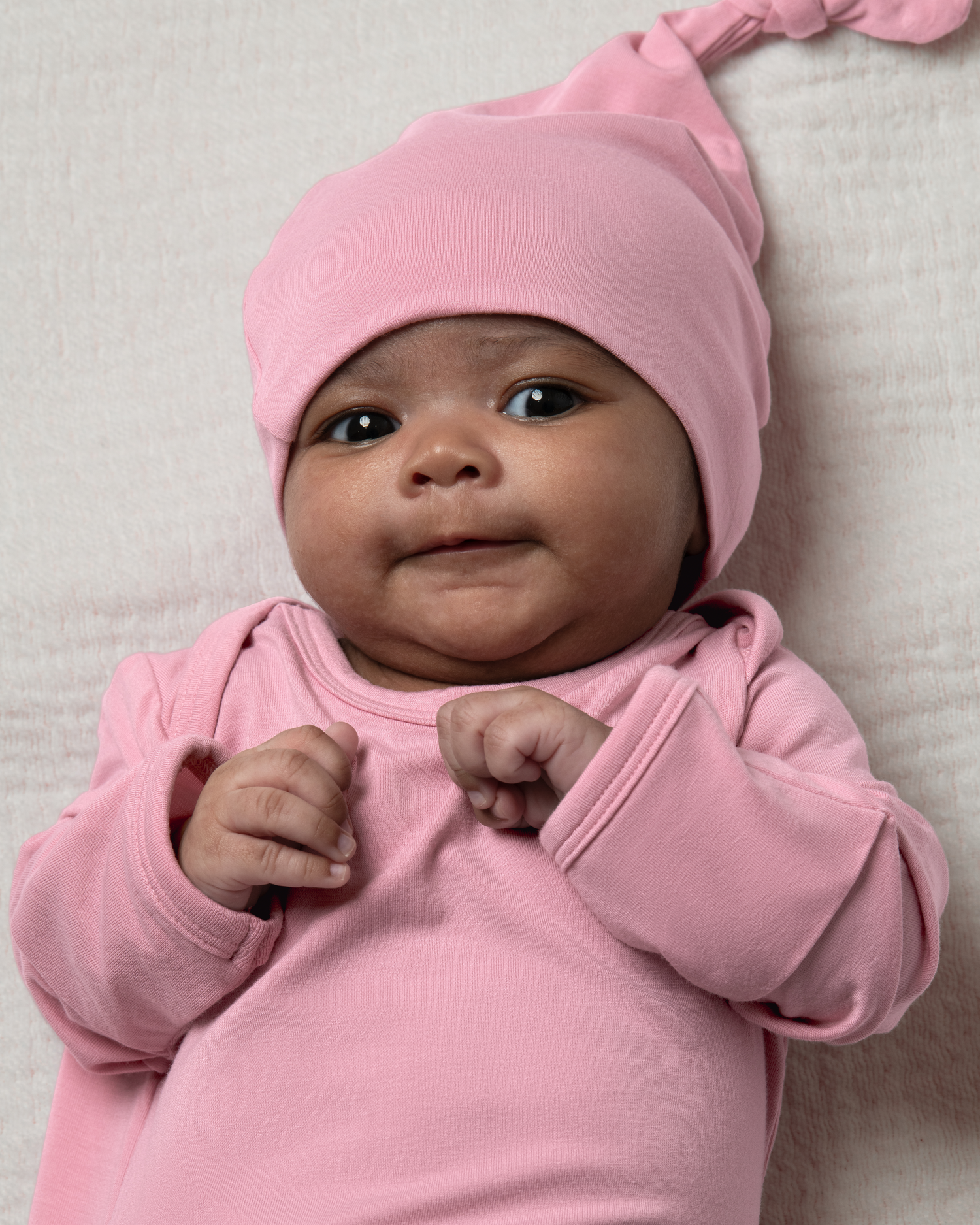 Baby wearing a Bamboo Knotted Baby Gown in Light Mauve on a light background