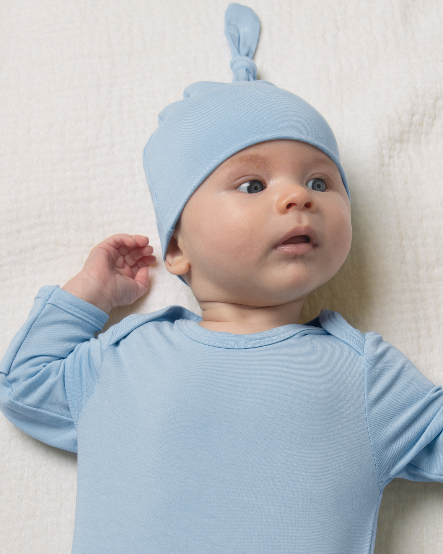 Baby wearing Bamboo Knotted Baby Gown in French Blue on a white background