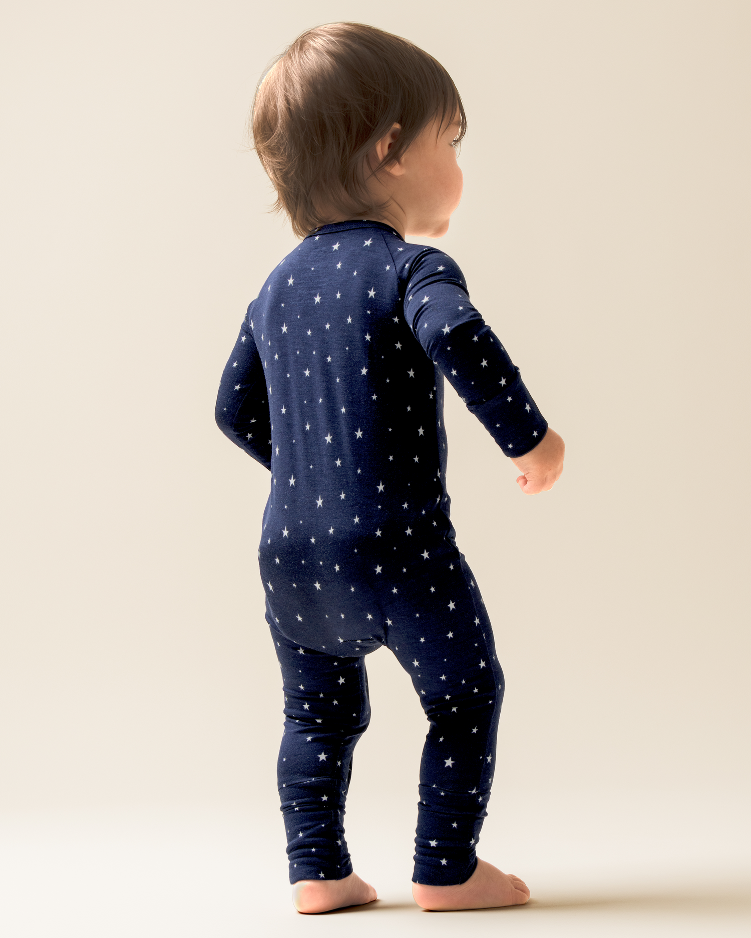Child wearing Bamboo Baby Pajamas in Navy Stars on a plain background
