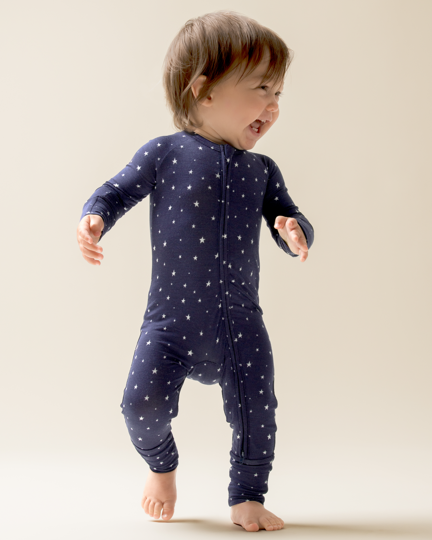 Child wearing Bamboo Baby Pajamas in Navy Stars on a plain background@model_info:Mosey is wearing 3-6 months.