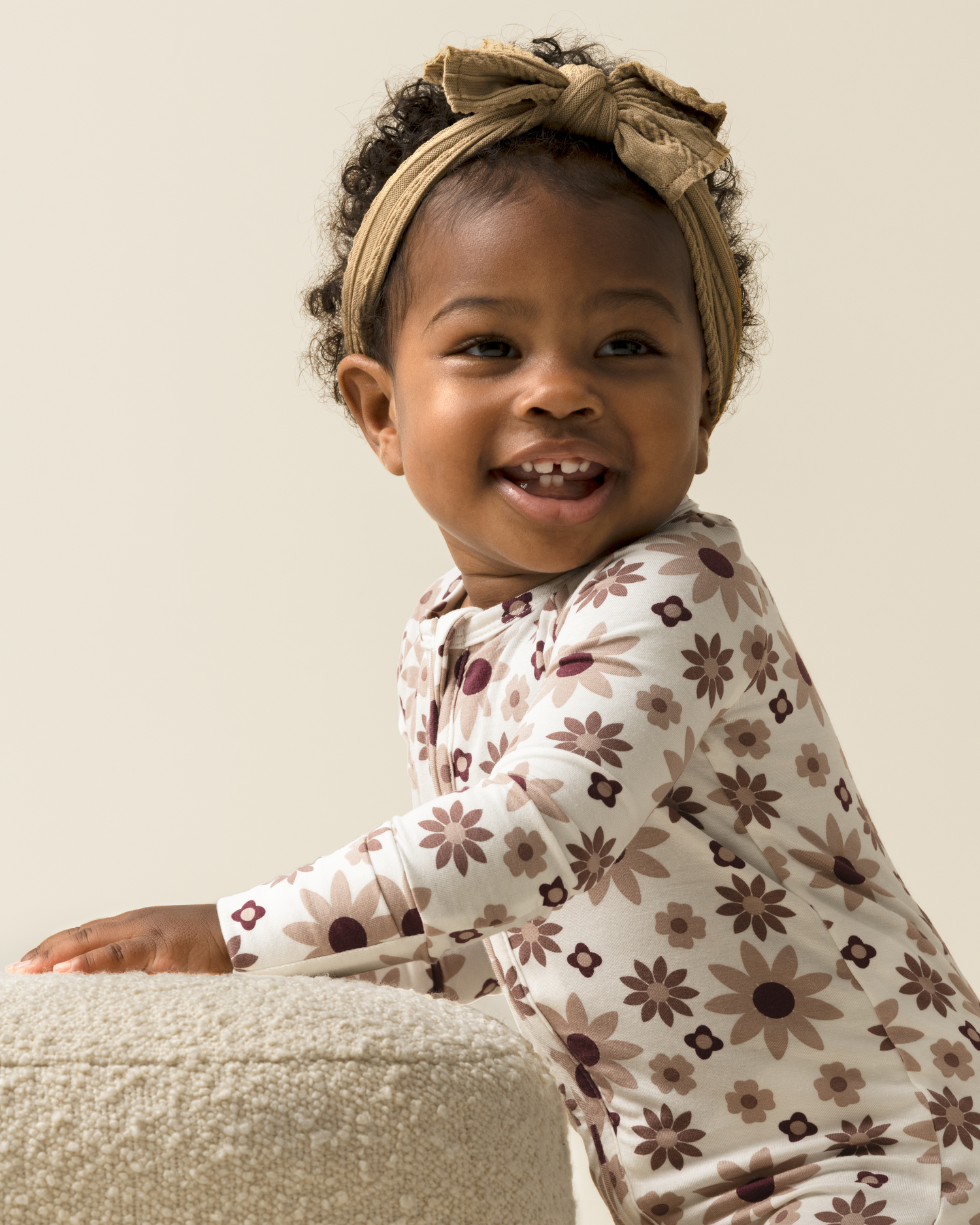 Child wearing Bamboo Baby Pajamas in Twilight Floral with a beige headband against a neutral background