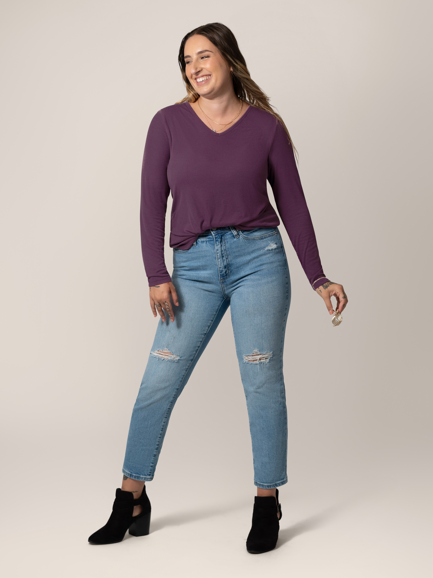 Full body image of model wearing the Ribbed Bamboo Maternity & Nursing Long Sleeve T-shirt in Mulberry, paired with jeans and booties