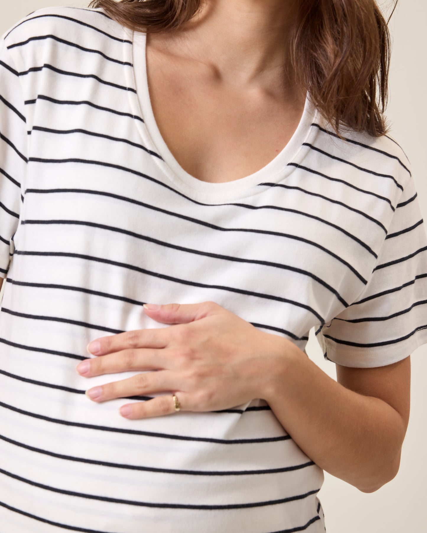 Close up of model wearing Relaxed Cotton Maternity & Nursing T-shirt in White & Black Stripe on a neutral background
