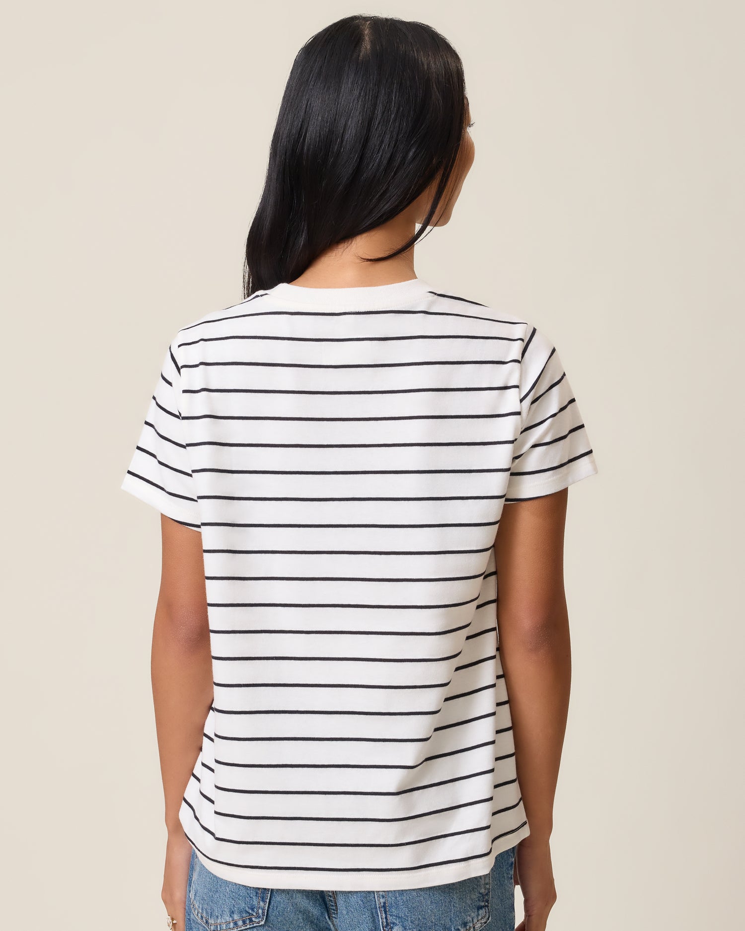 Back view of model wearing Classic Cotton Nursing T-shirt in White & Black Stripe on a neutral background
