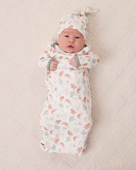 Baby wearing the Cozy Bamboo Baby Gown & Hat in Cozy Holiday pattern - gingerbread men, Christmas trees, candy canes, Santa, snowmen@model_info:Liora is 5 weeks old.