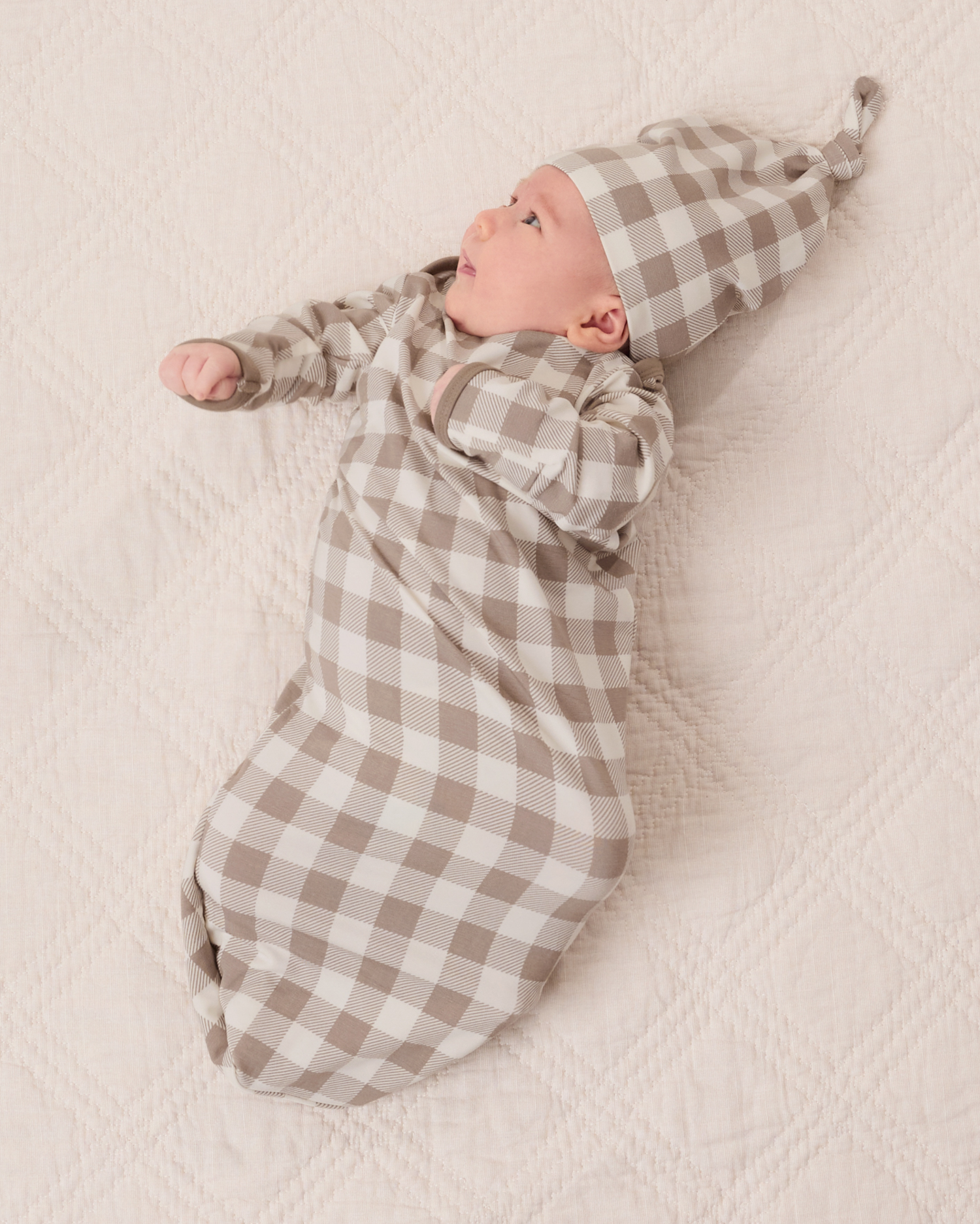 Baby wearing the Cozy Bamboo Baby Gown & Hat in Taupe Gingham checkered fabric@model_info:Liora is 5 weeks old.