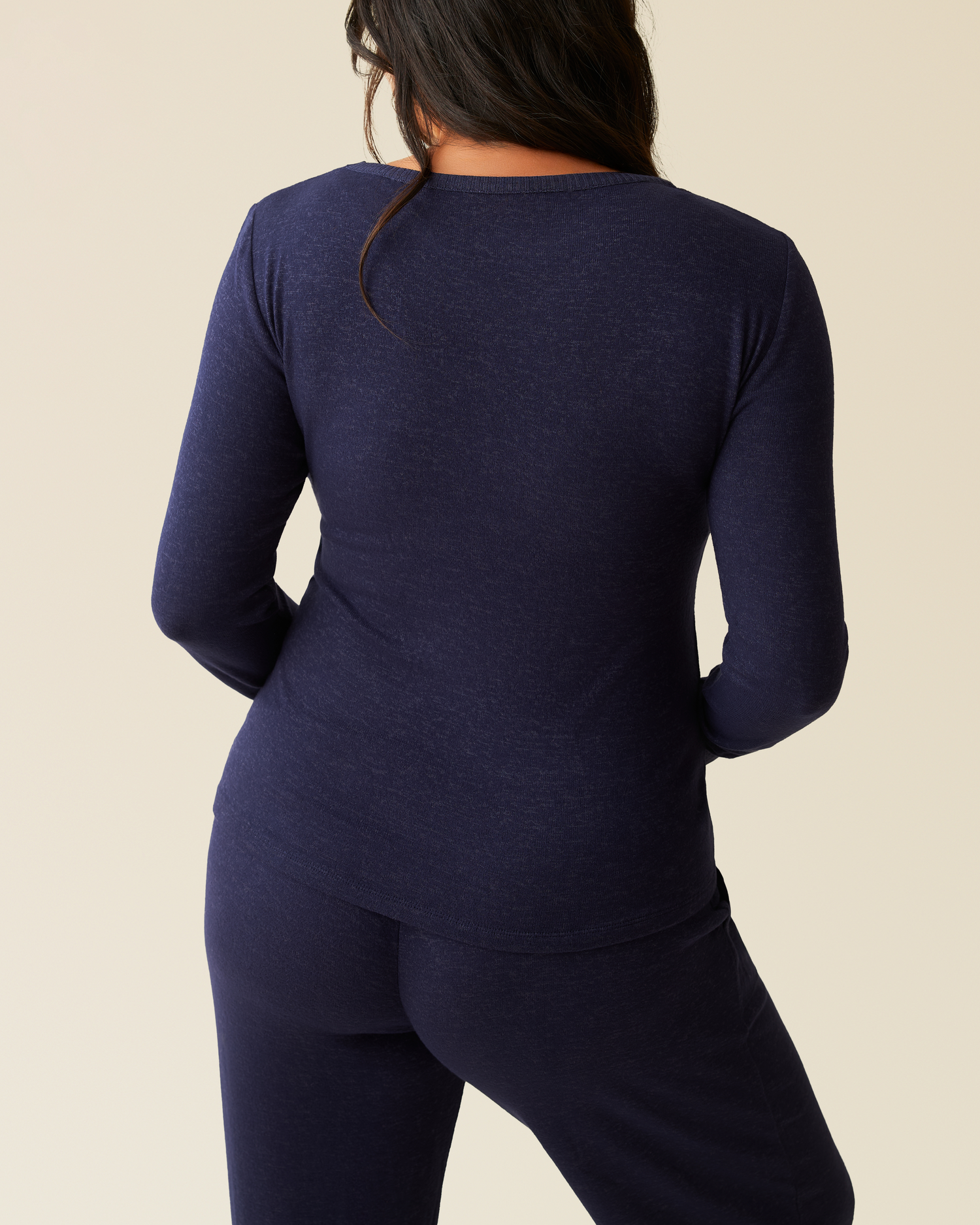 Back view of person wearing CozyKnit Nursing Pajama & Lounge Set in Navy on a beige background