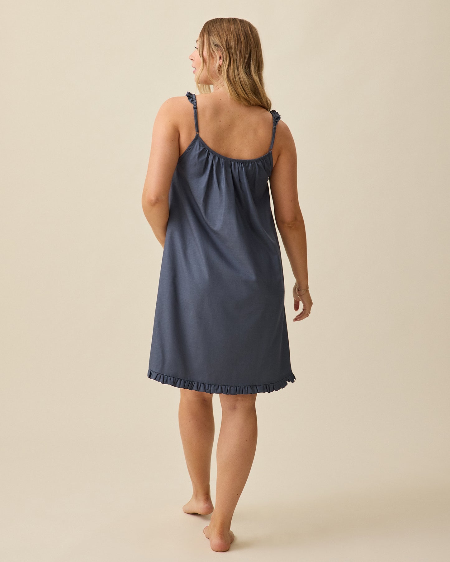 Model displaying back view of Dreamy Cotton Maternity & Nursing Nightgown in Midnight Blue on a beige background
