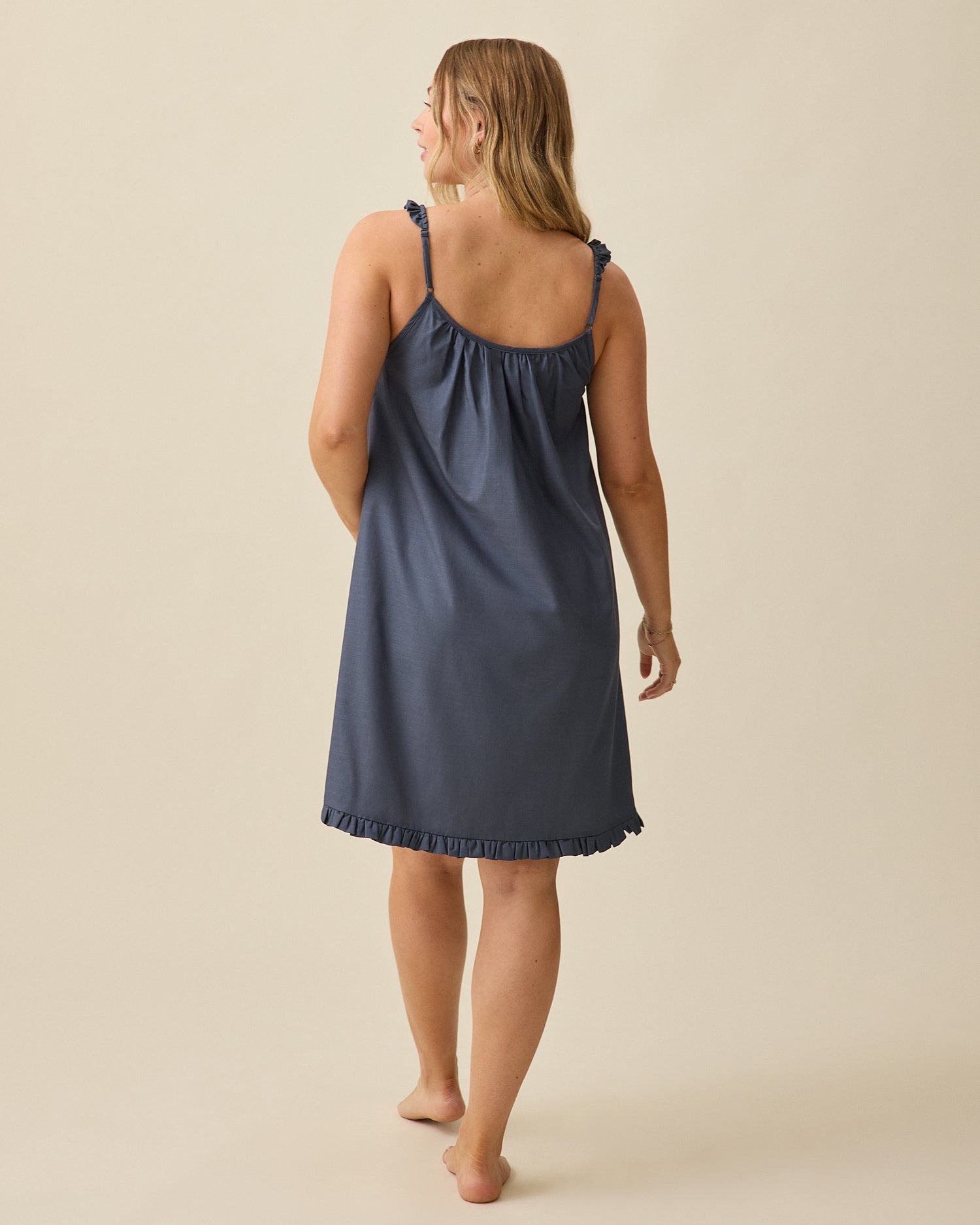 Model displaying back view of Dreamy Cotton Maternity & Nursing Nightgown in Midnight Blue on a beige background