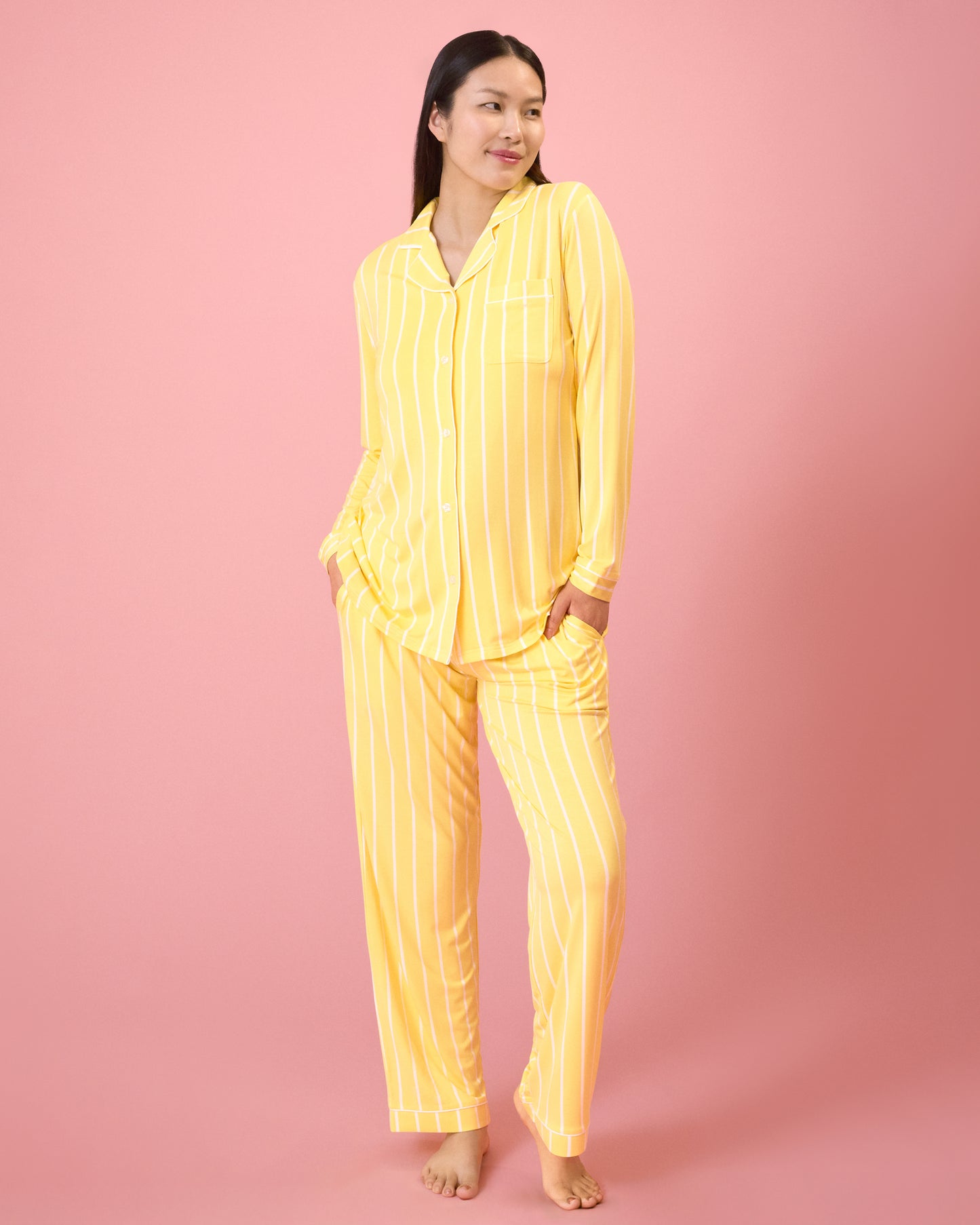 Front view of model wearing Clea Bamboo Long Sleeve Pajama Set in Dandelion Stripe on a pink background@model_info:Cassie is 5'9" and wearing a Small.