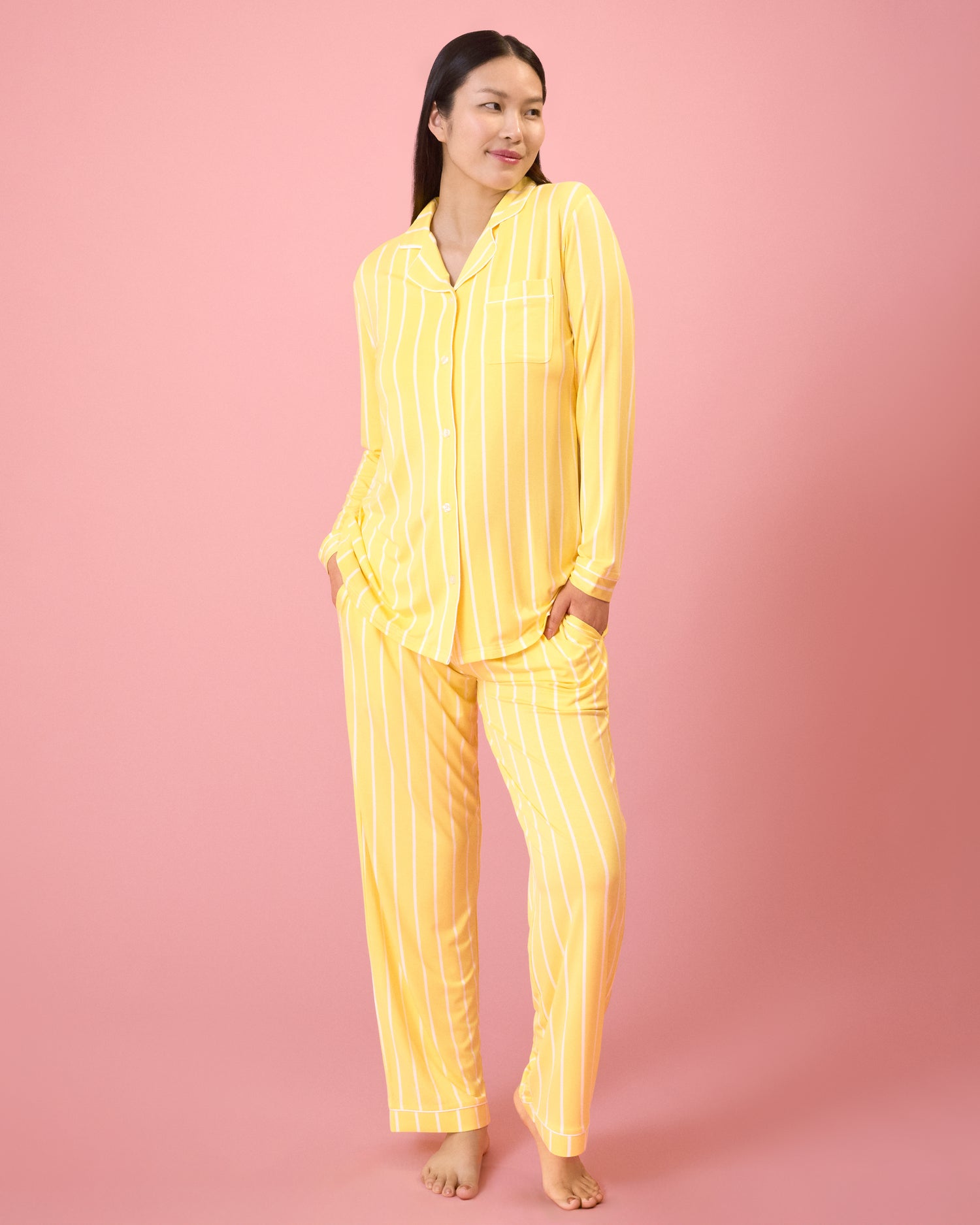 Front view of model wearing Clea Bamboo Long Sleeve Pajama Set in Dandelion Stripe on a pink background@model_info:Cassie is 5'9" and wearing a Small.