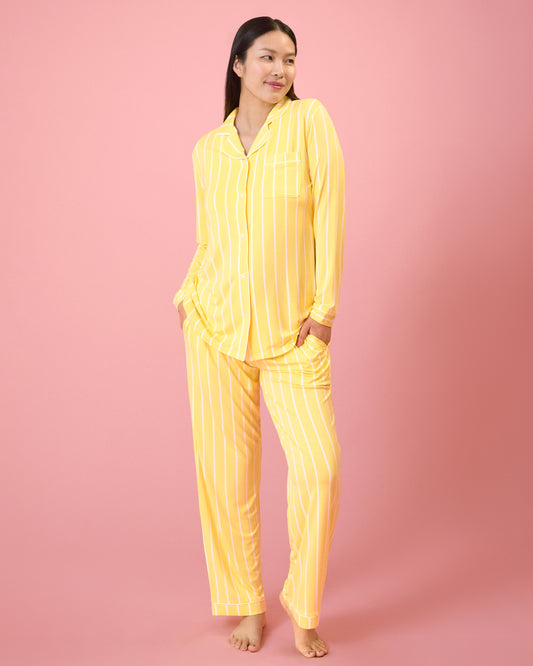 Front view of model wearing Clea Bamboo Long Sleeve Pajama Set in Dandelion Stripe on a pink background@model_info:Cassie is 5'9" and wearing a Small.
