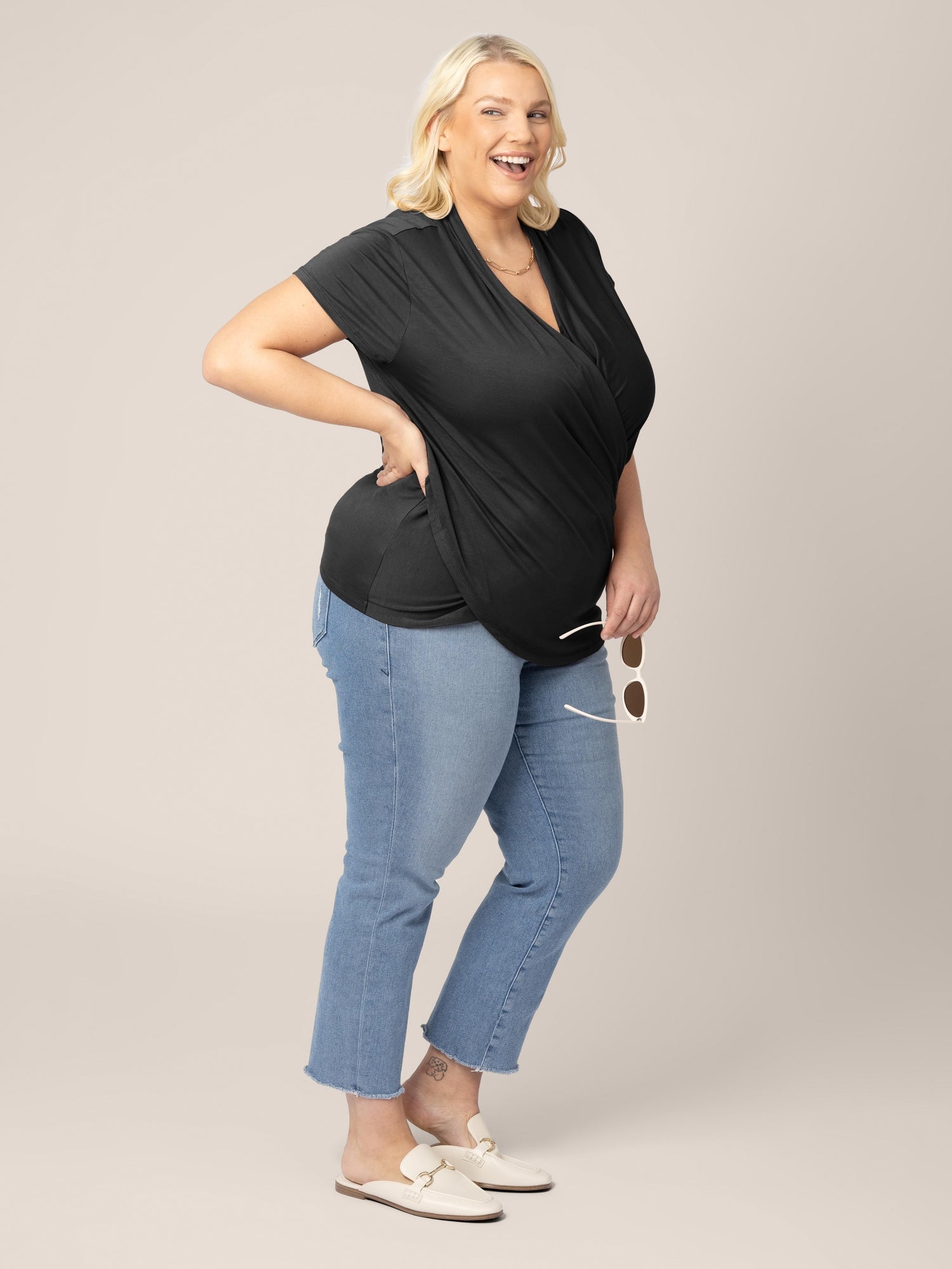 Full shot of model wearing the Bamboo Draped Nursing Top in black, paired with jeans