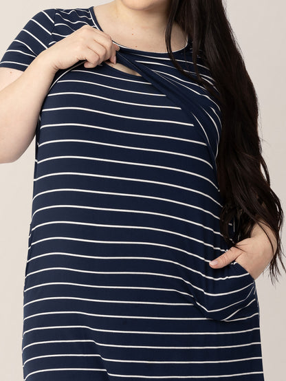 Model pulling up the convenient nursing panel on the Eleanora Bamboo Maternity & Nursing Dress in Navy Stripe