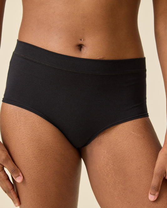 Model is wearing and Every Stage Brief in Black on a beige background @model_info:Sahana is wearing a Small.